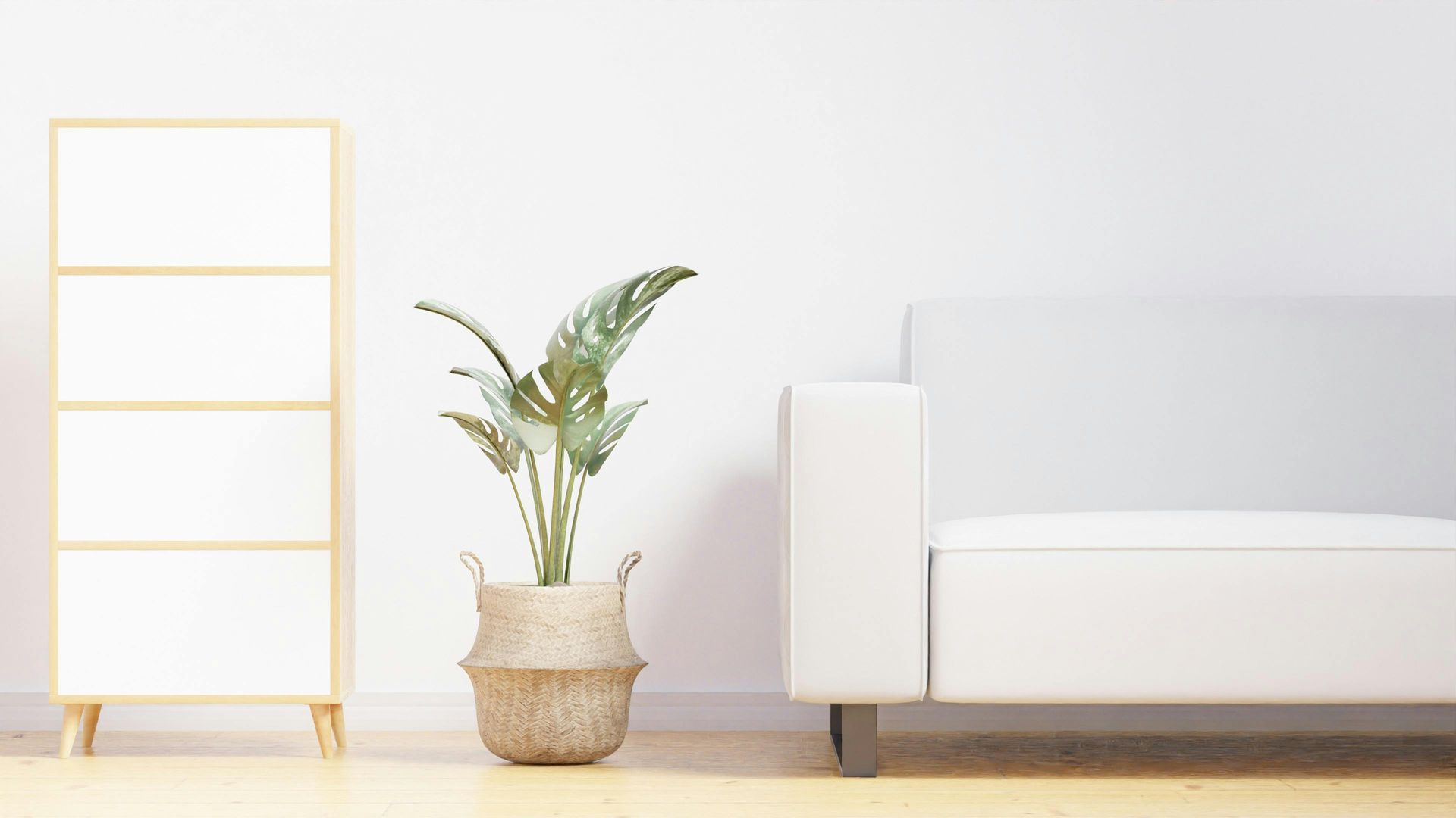 Minimal living room with a white sofa, potted plant, and gold ladder shelf on a light wood floor.