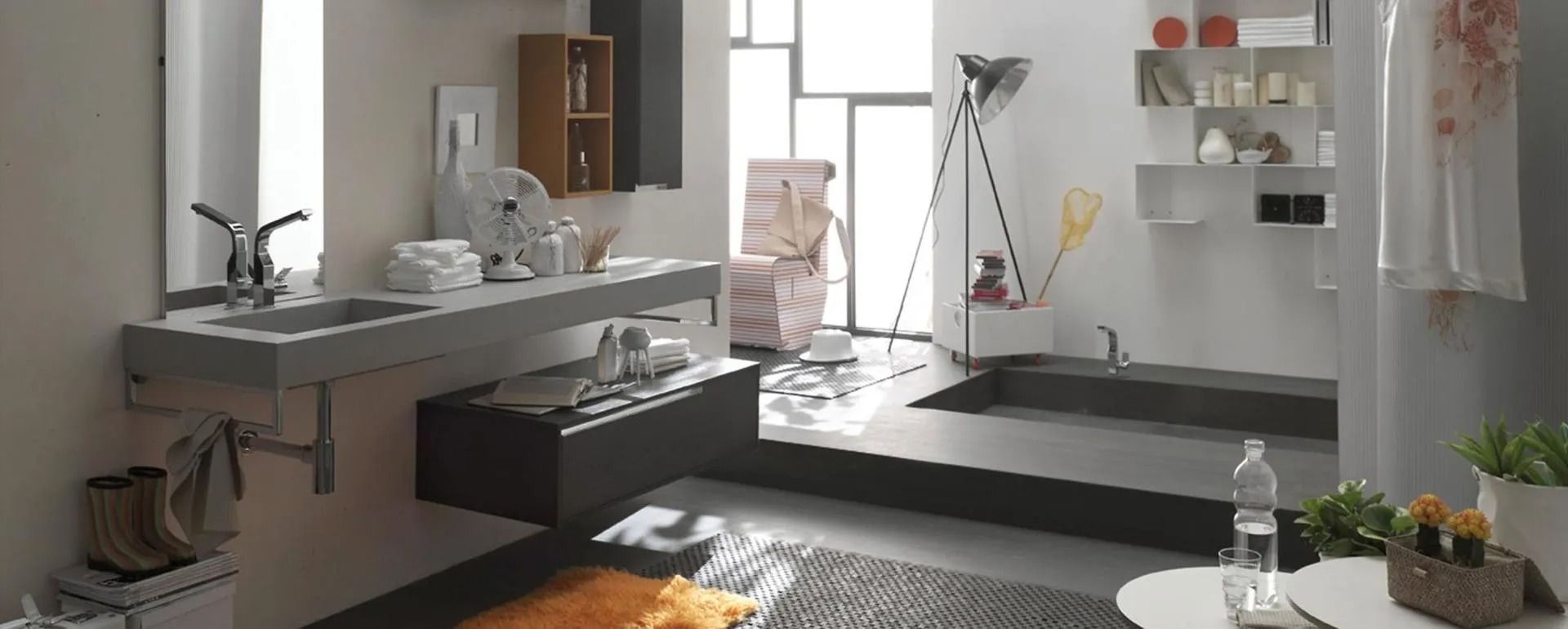 Bagno moderno con lavandino, mobili e vasca da bagno con una lampada unica e una finestra sul retro.