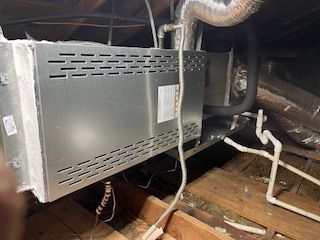 An air conditioner is installed in the attic of a house.