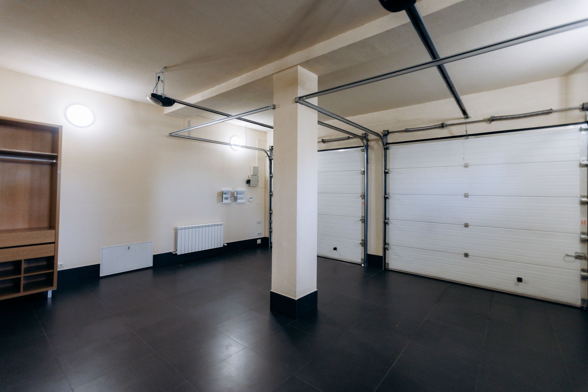 Interior of a garage with closed sectional doors and overhead track systems.