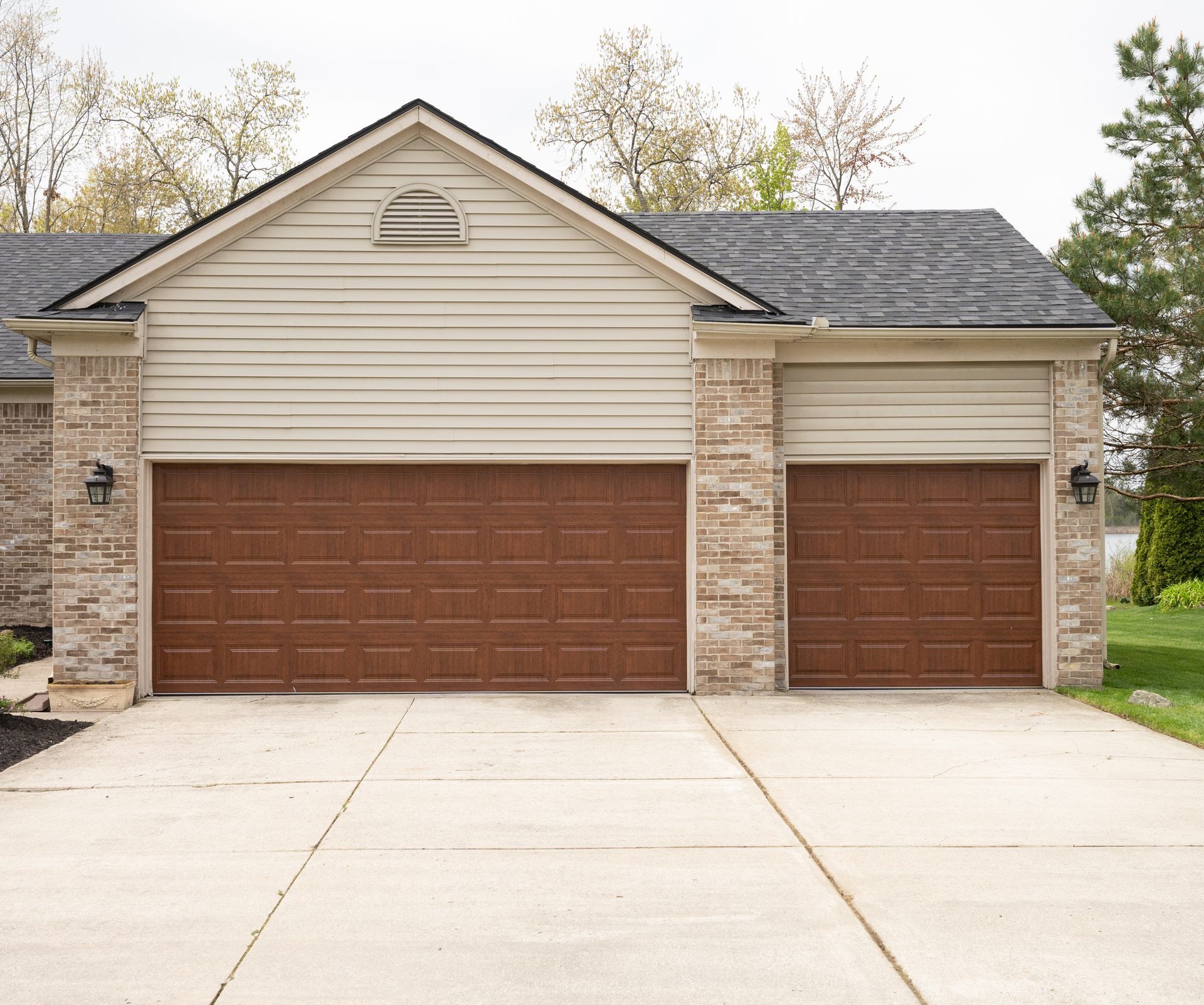 residential garage exterior featuring two brown paneled garage doors. residential garage exterior featuring two brown paneled garage doors.