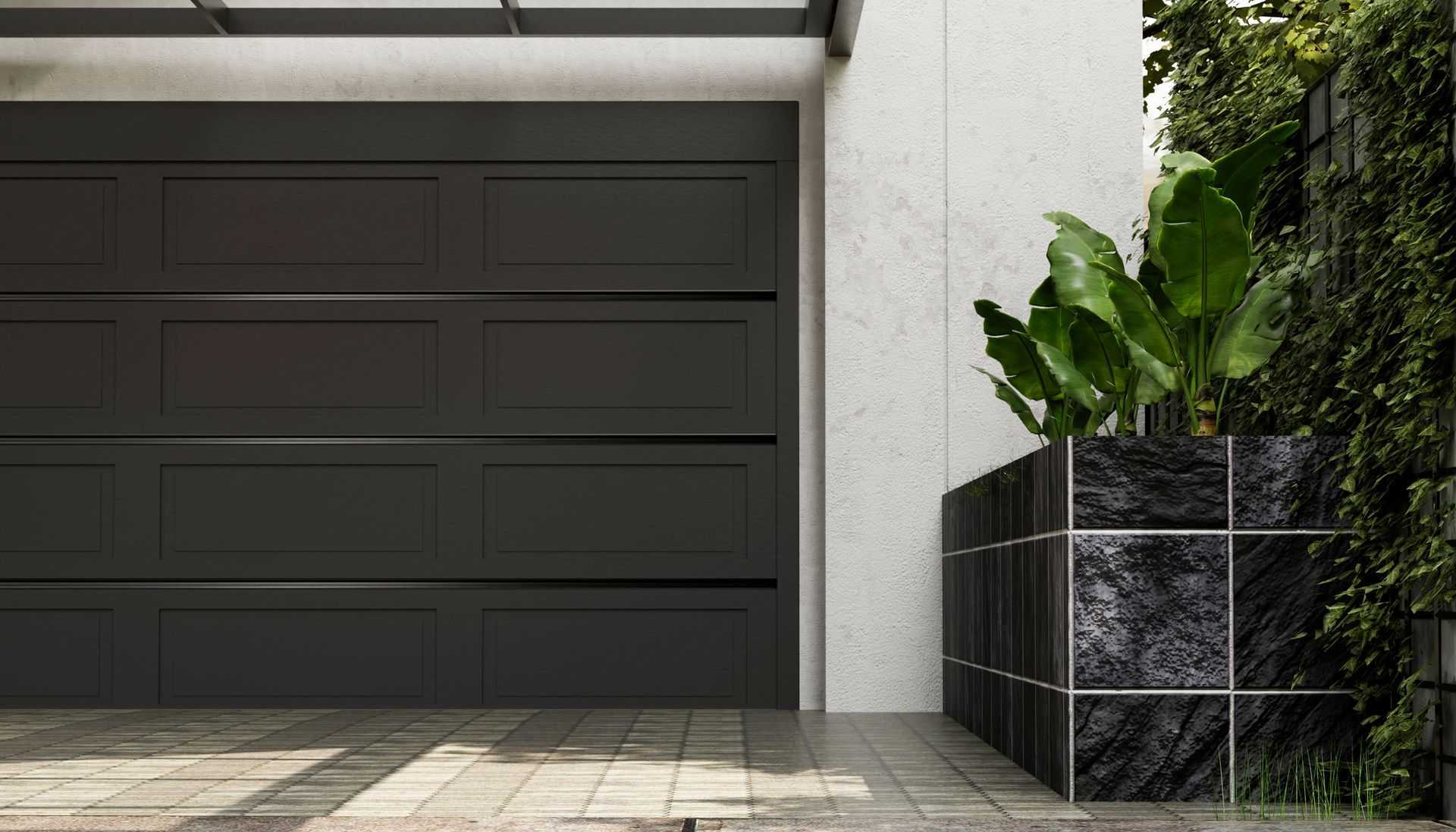 Front view of a black metal garage door in the foreground with plants on one side.