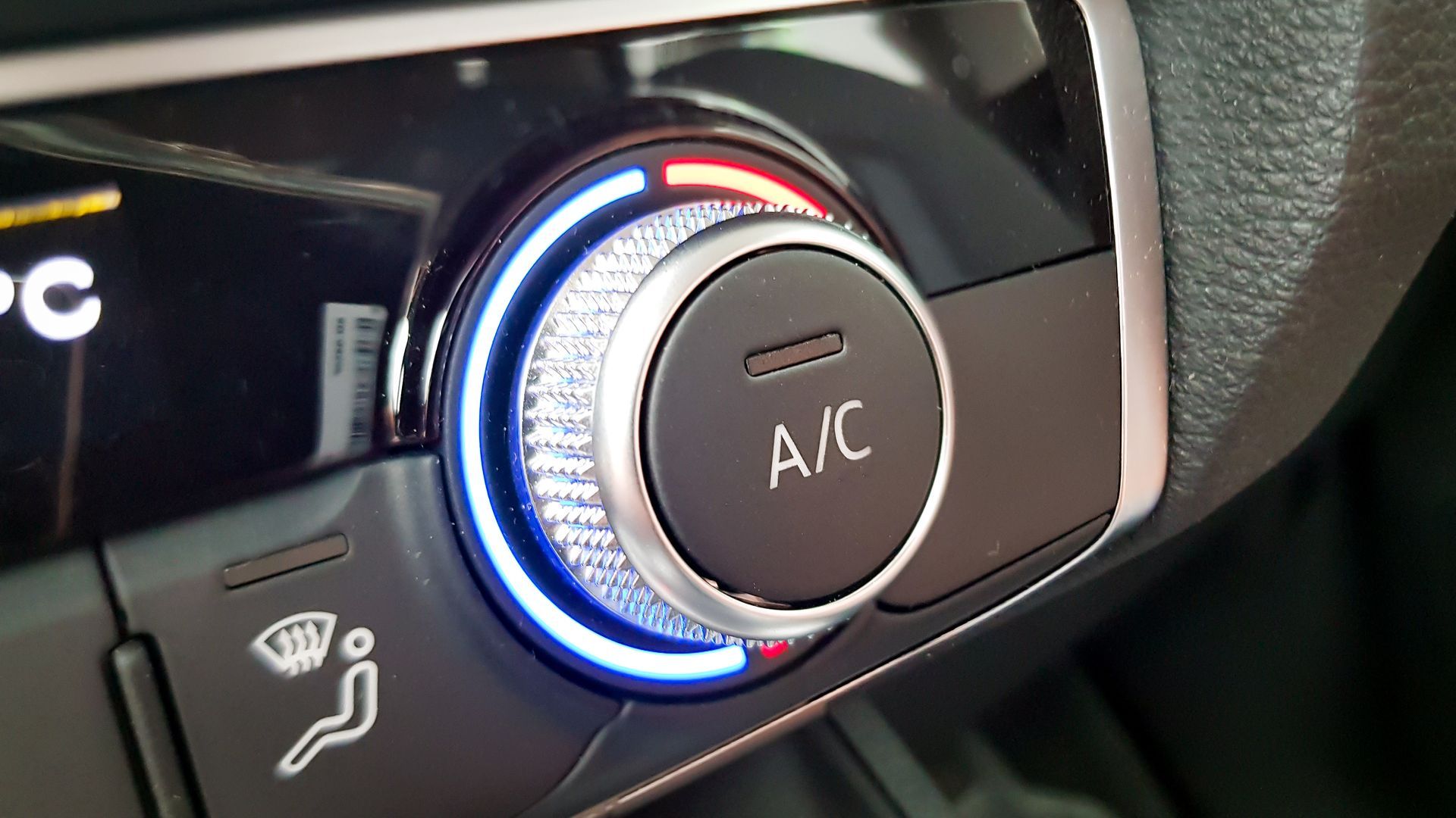 Car's climate control knob with blue/red lights; has A/C button. | University Auto Repair