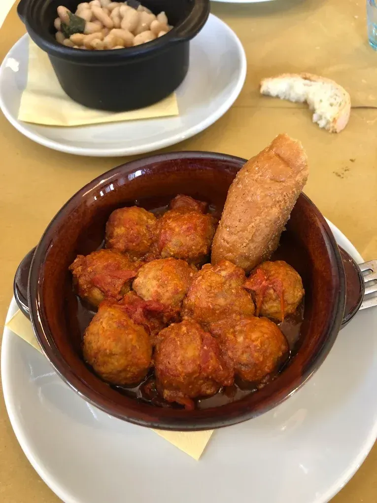 Due ciotole di cibo fritto su un tavolo, una con un grissino sopra.