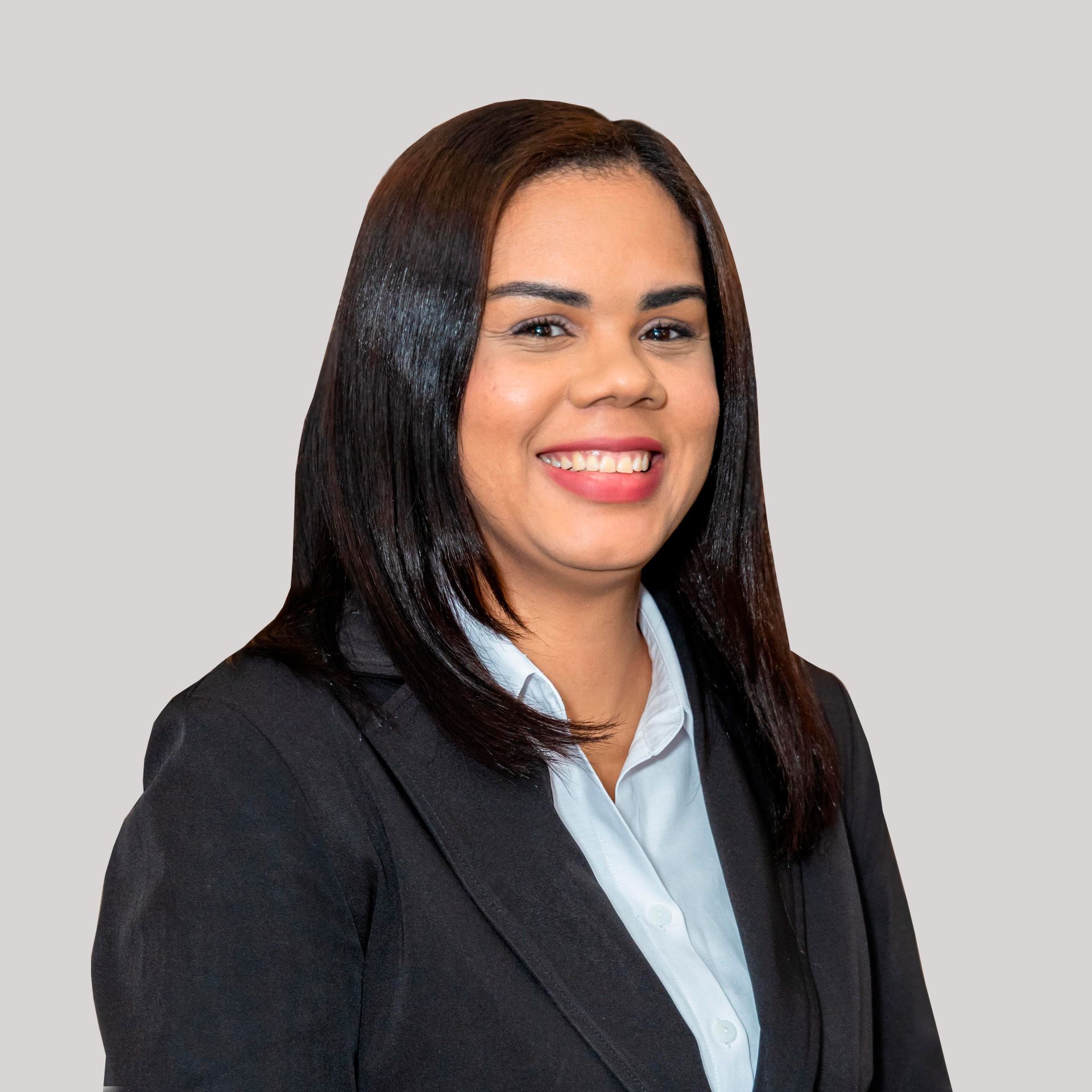 A woman in a suit and blue shirt is smiling for the camera.