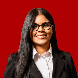 A woman wearing glasses and a suit is smiling on a red background.