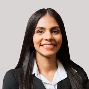 A woman in a suit and white shirt is smiling for the camera.