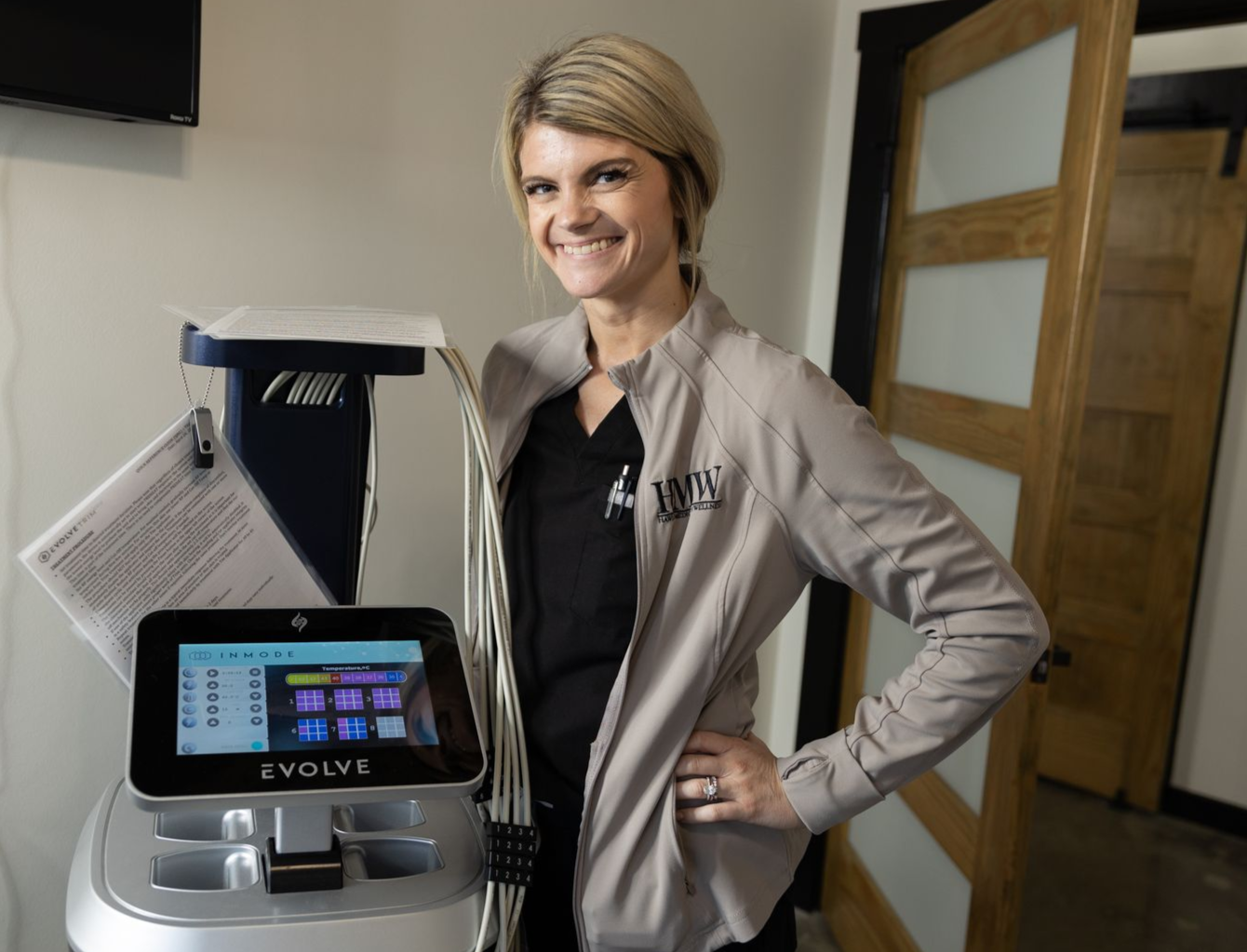 A woman is measuring another woman 's leg with a tape measure