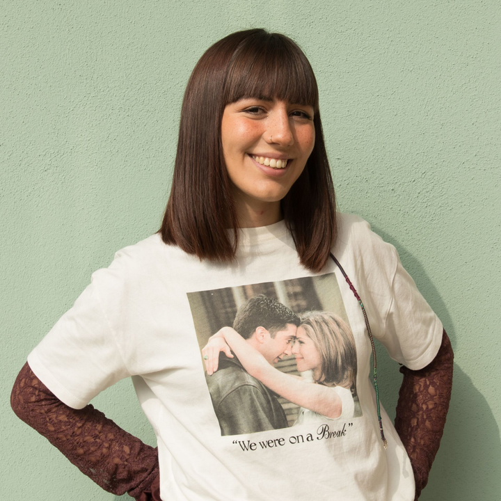 Una persona sorridente indossa una maglietta bianca con la foto di Ross e Rachel e la scritta 