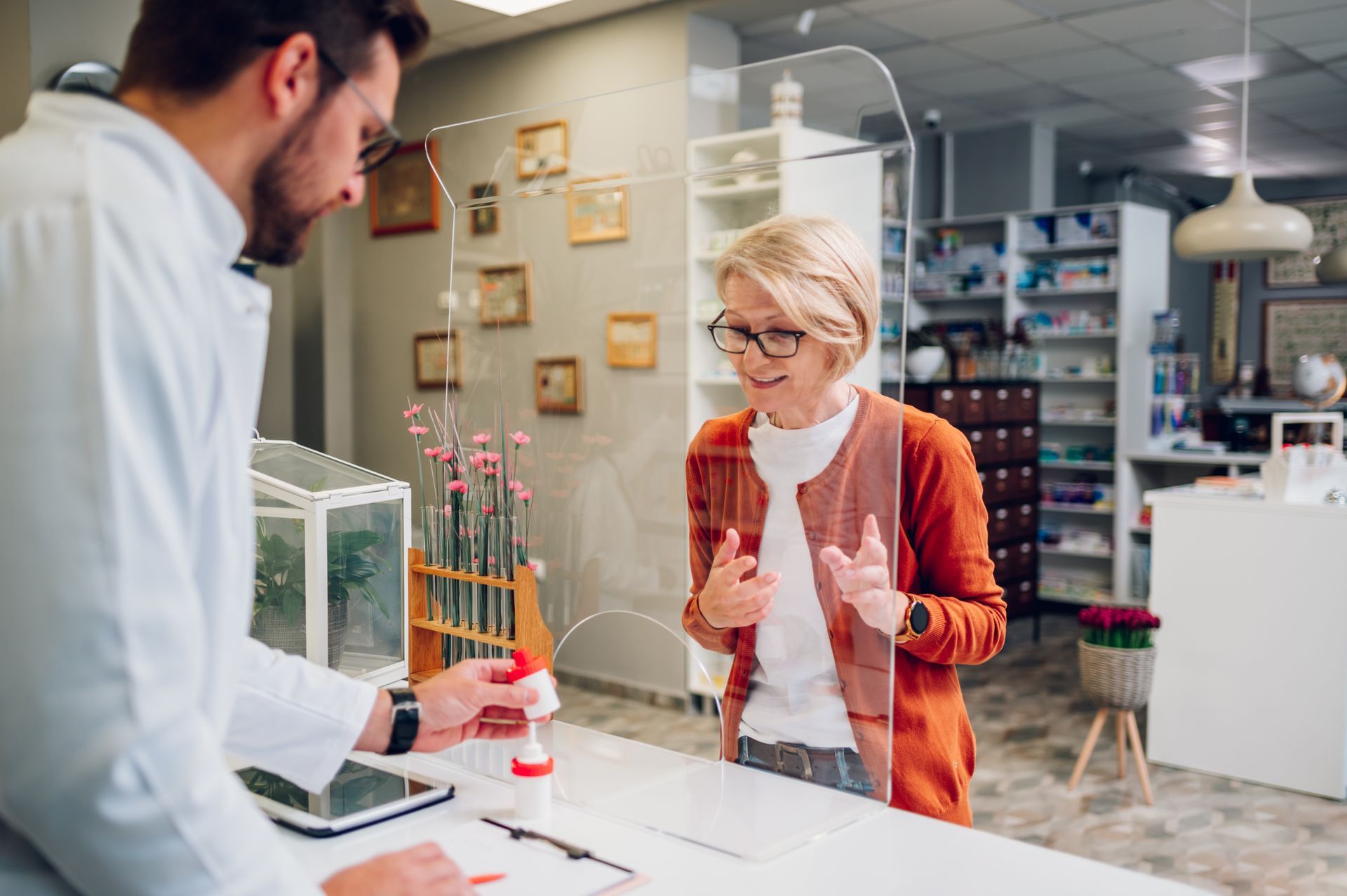 A woman is talking to a pharmacist in a pharmacy.