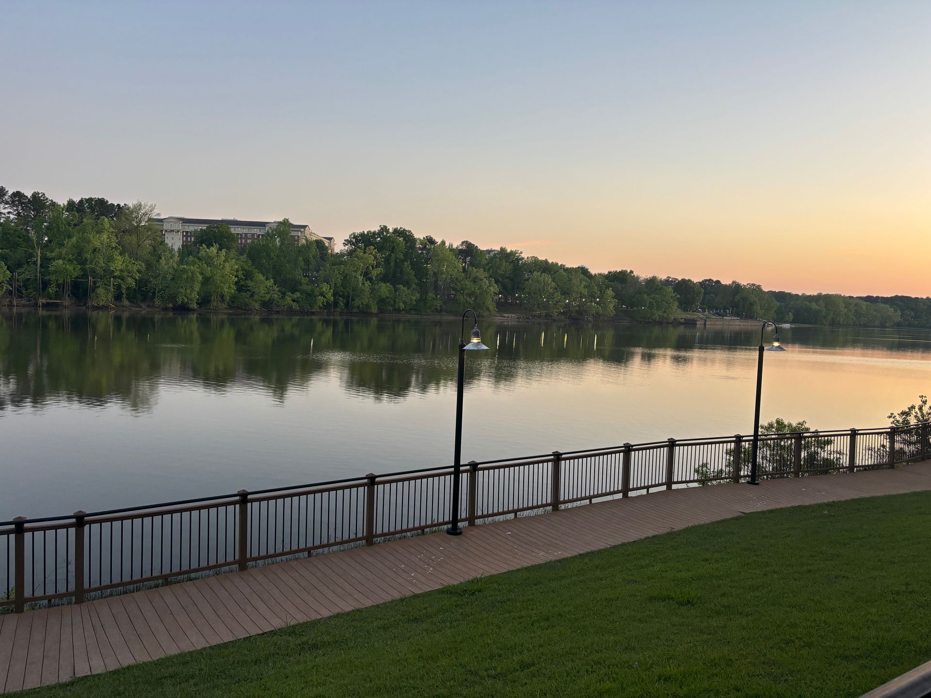 A lake with a brick walkway along the shore