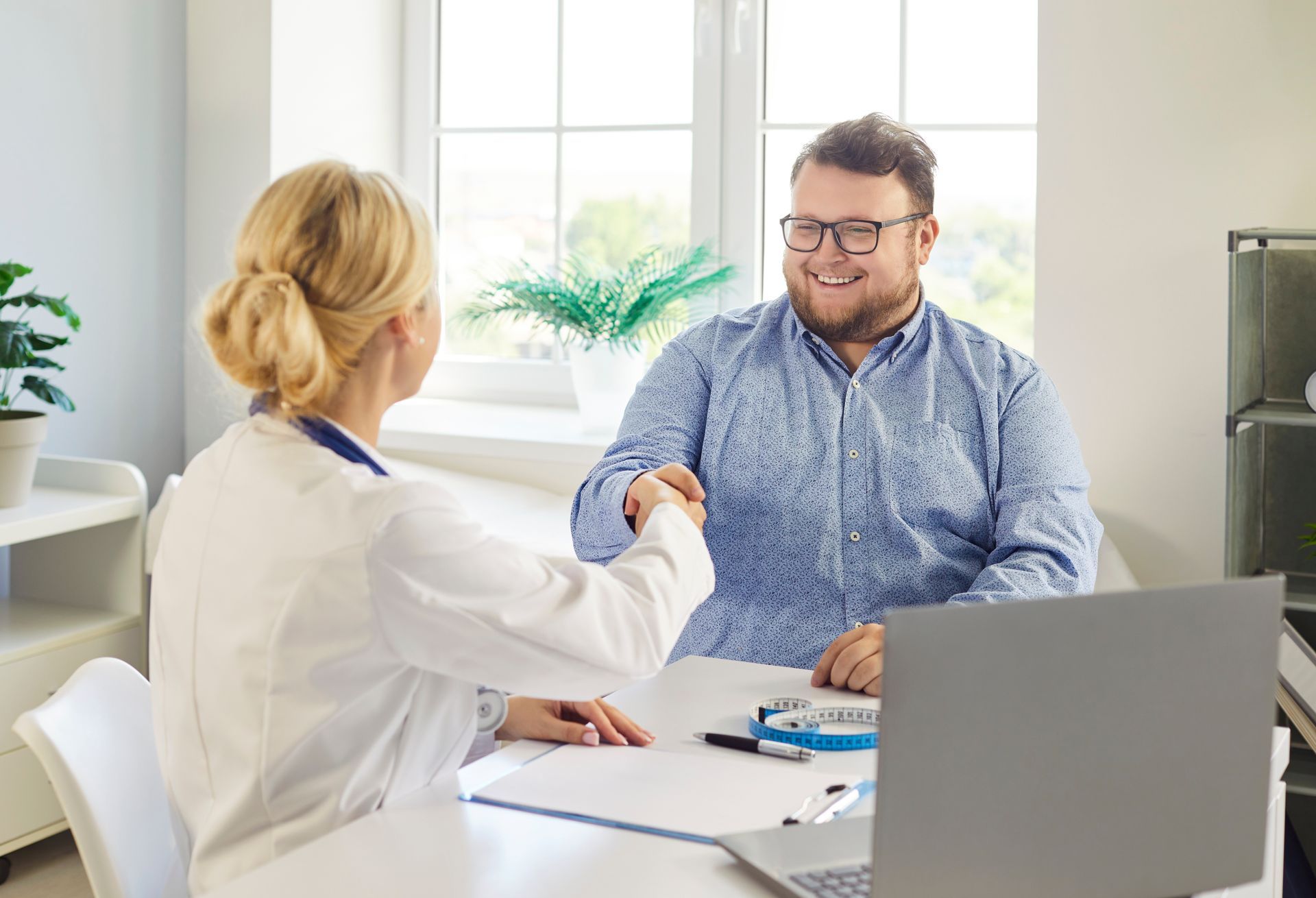 A woman is sitting at a table talking to a little girl.