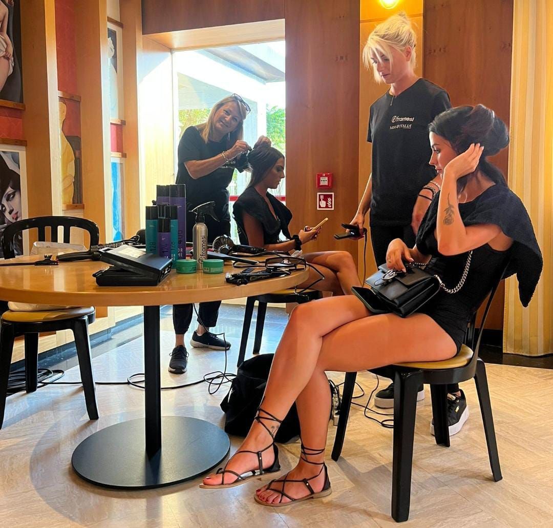 Una donna è seduta a un tavolo in una stanza con altre persone