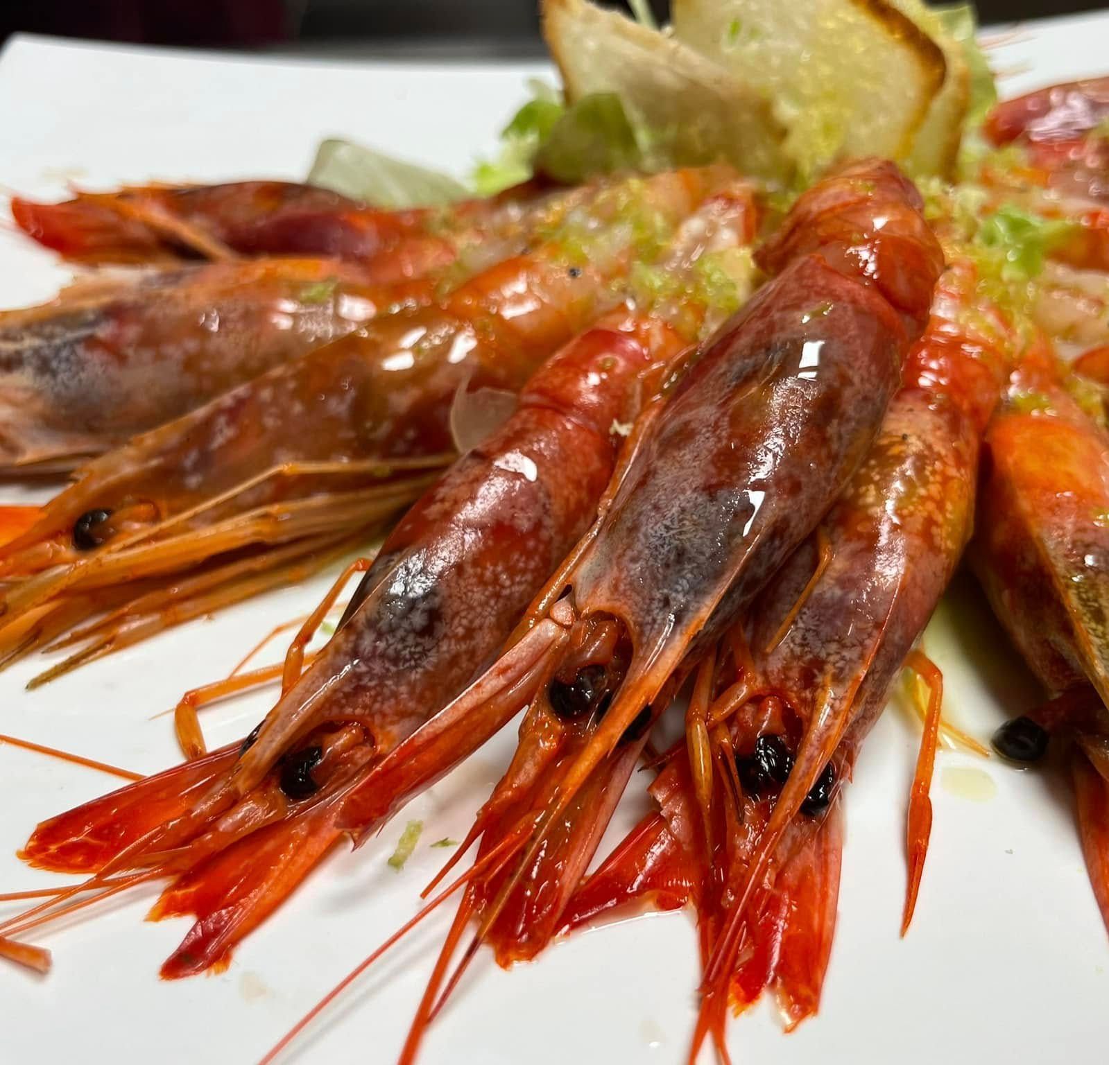 Gamberi grigliati con spicchi di limone su un piatto bianco