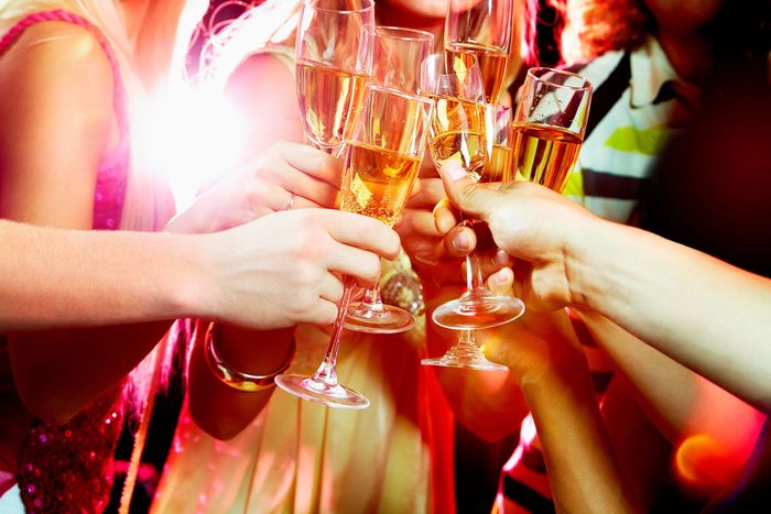 Mani che alzano calici di champagne in una celebrazione vivace e colorata
