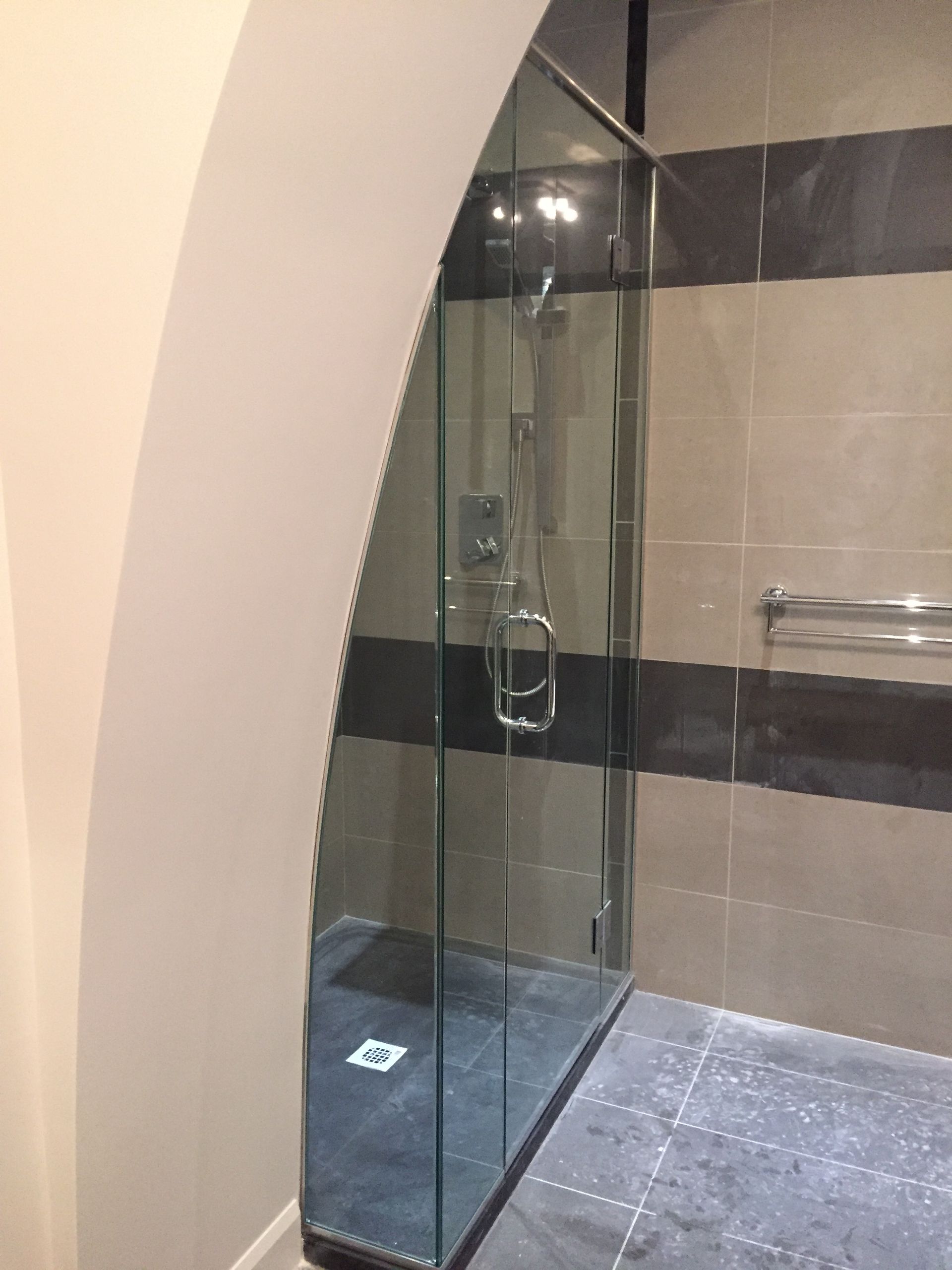 Une salle de bain avec une douche à l'italienne avec une porte vitrée