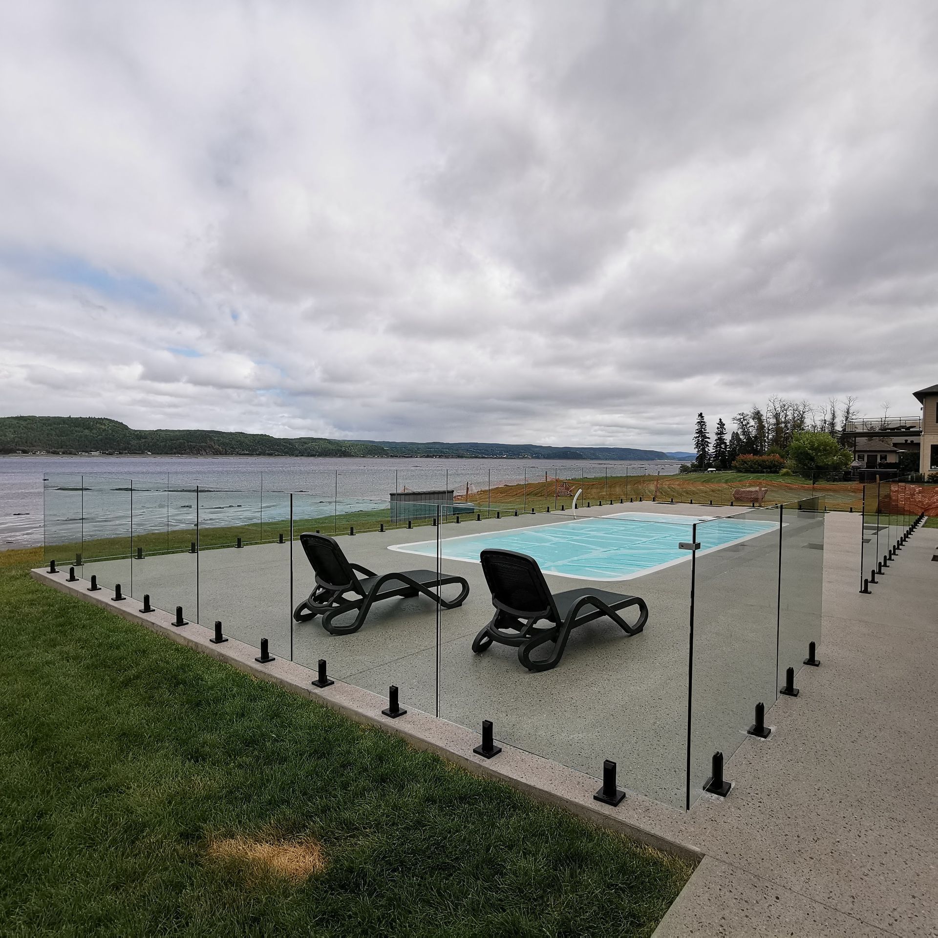 Une piscine entourée d'une clôture en verre
