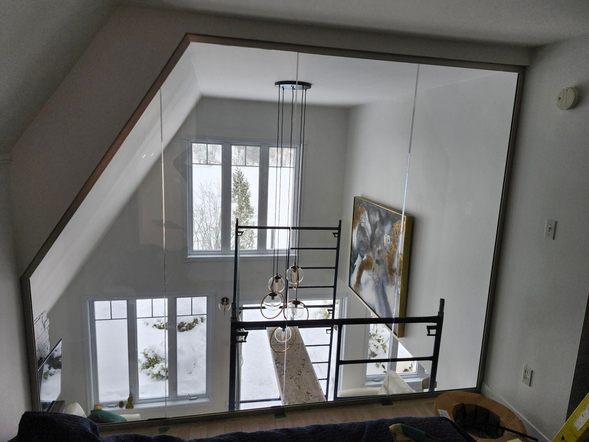 Une pièce avec un escalier et un tableau au mur