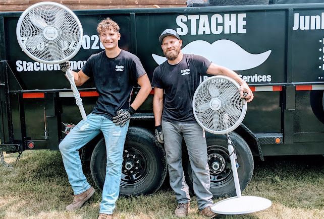 two Stache Junk Removal team members hold standing fast by trailer, household junk removal in Lancaster and central Ohio