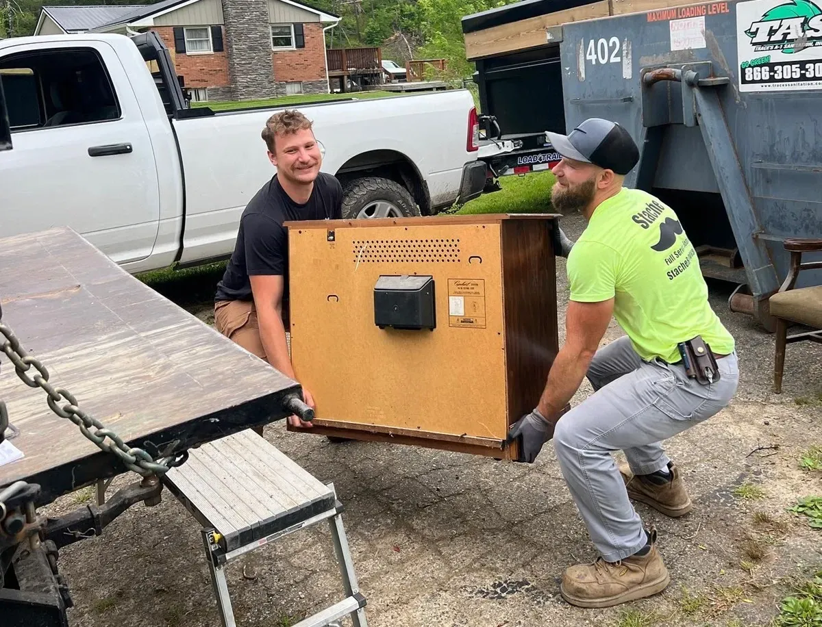Stache-Junk-Removal-team-lifting-an-old-tube-television-into-the-trailer-appliance-removal