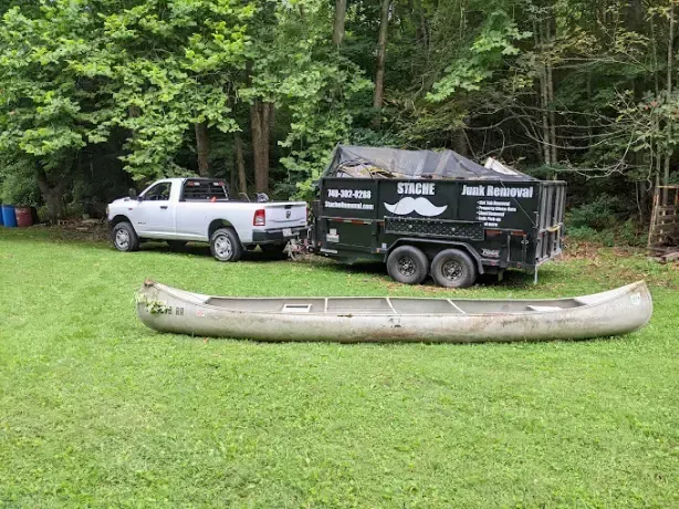 A truck is towing a canoe on a trailer.