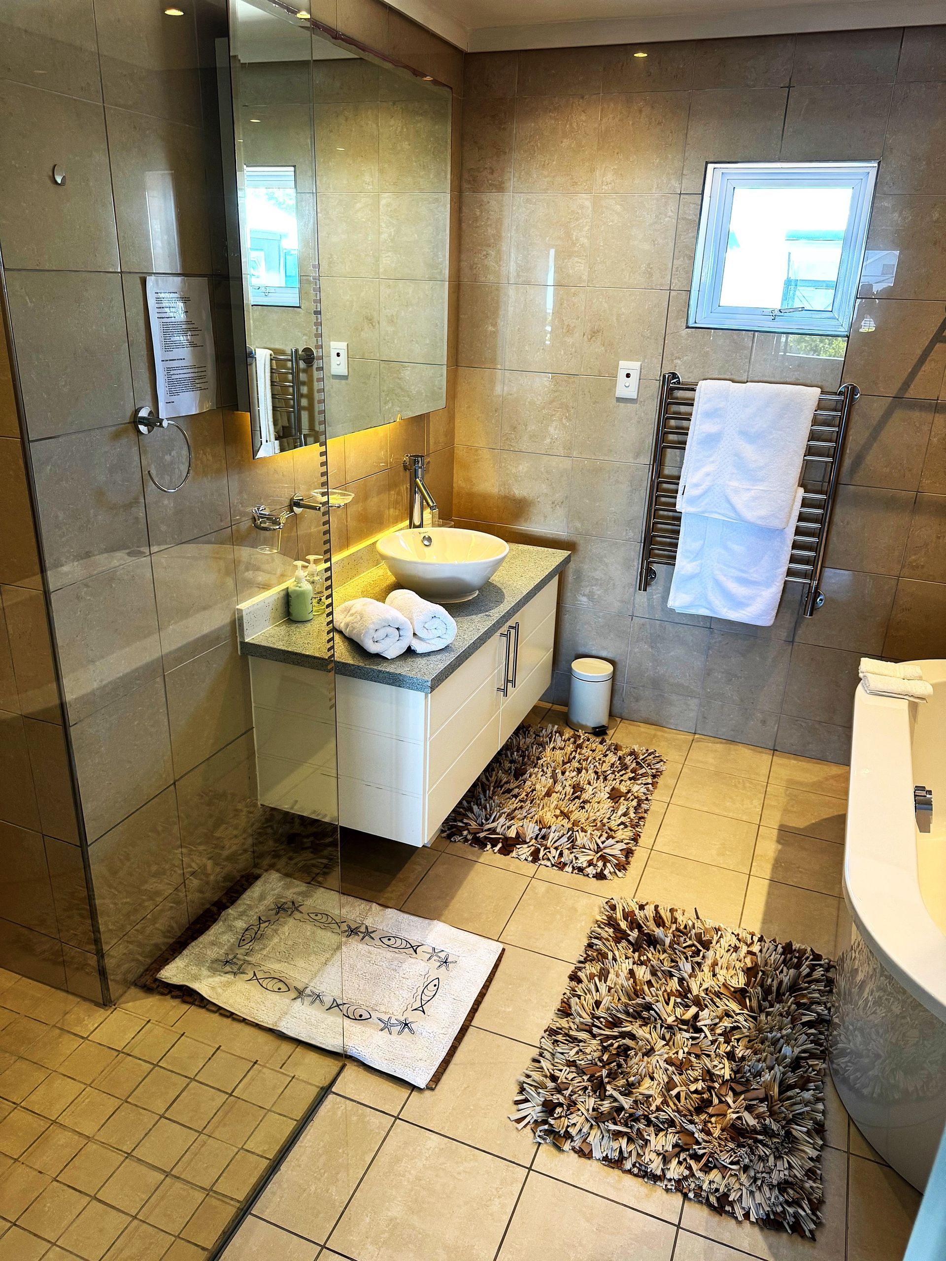 A bathroom with a sink , mirror , and bathtub.
