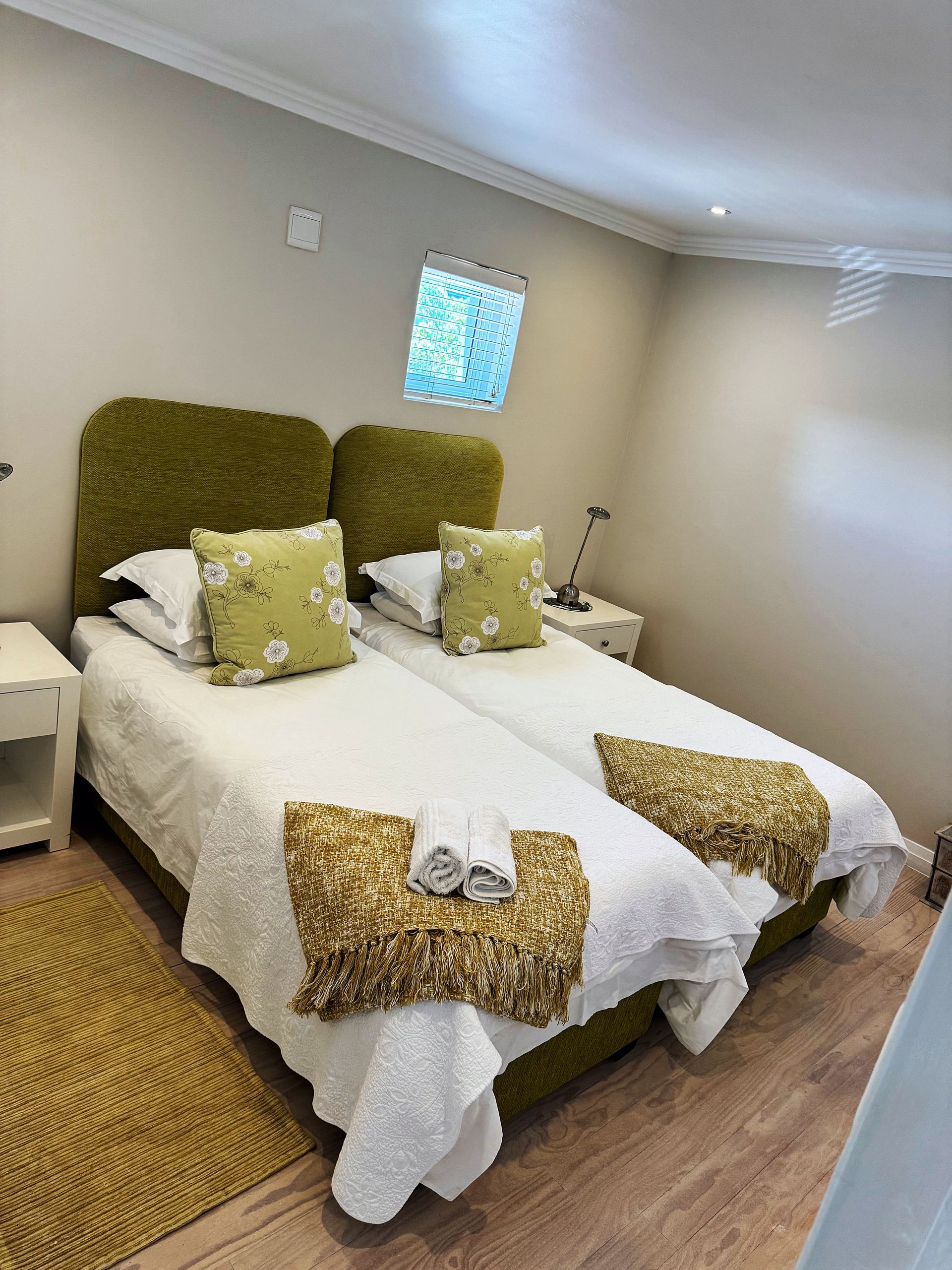 A bedroom with two beds and two nightstands