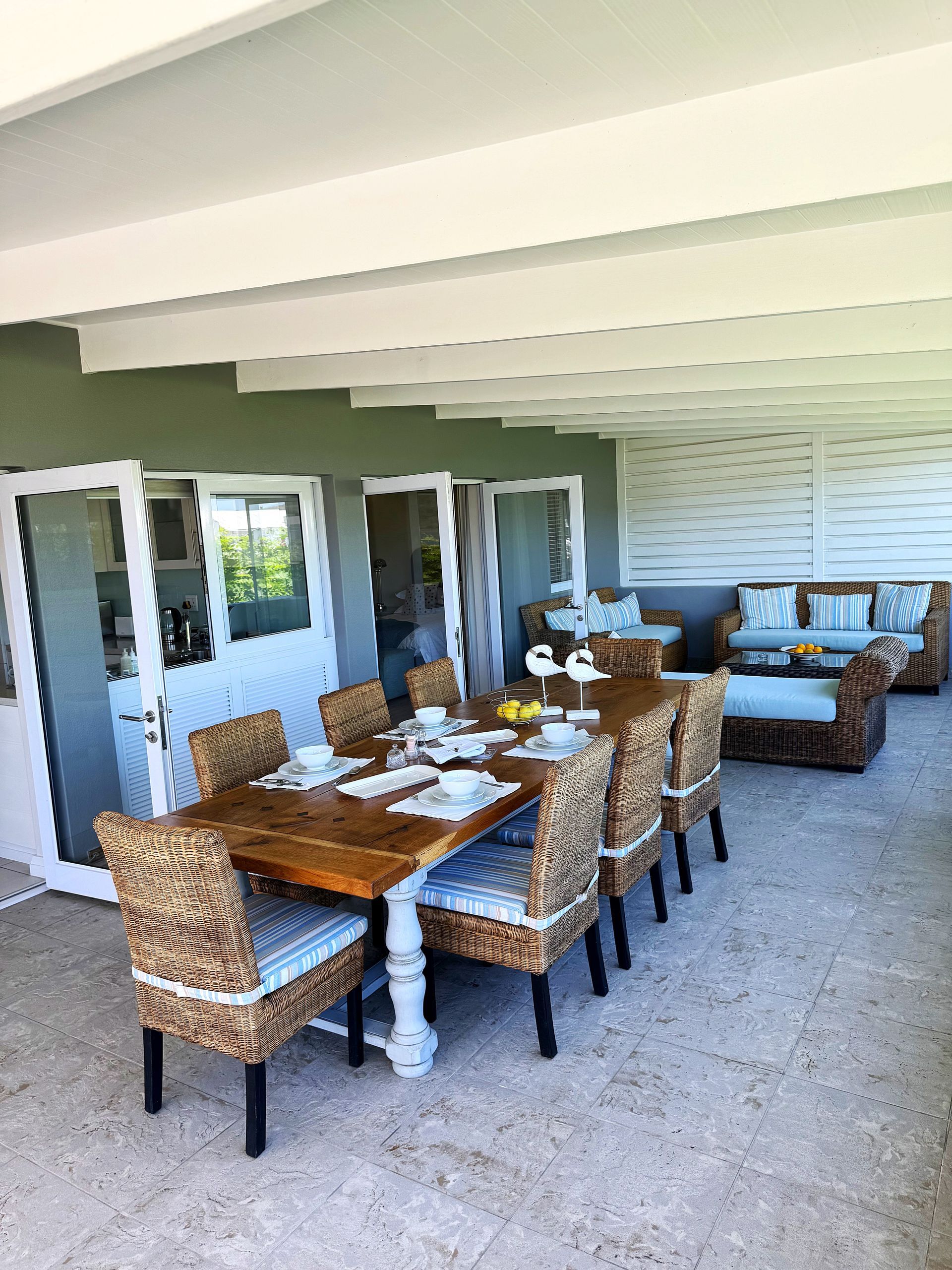 A patio with a table and chairs and a couch.