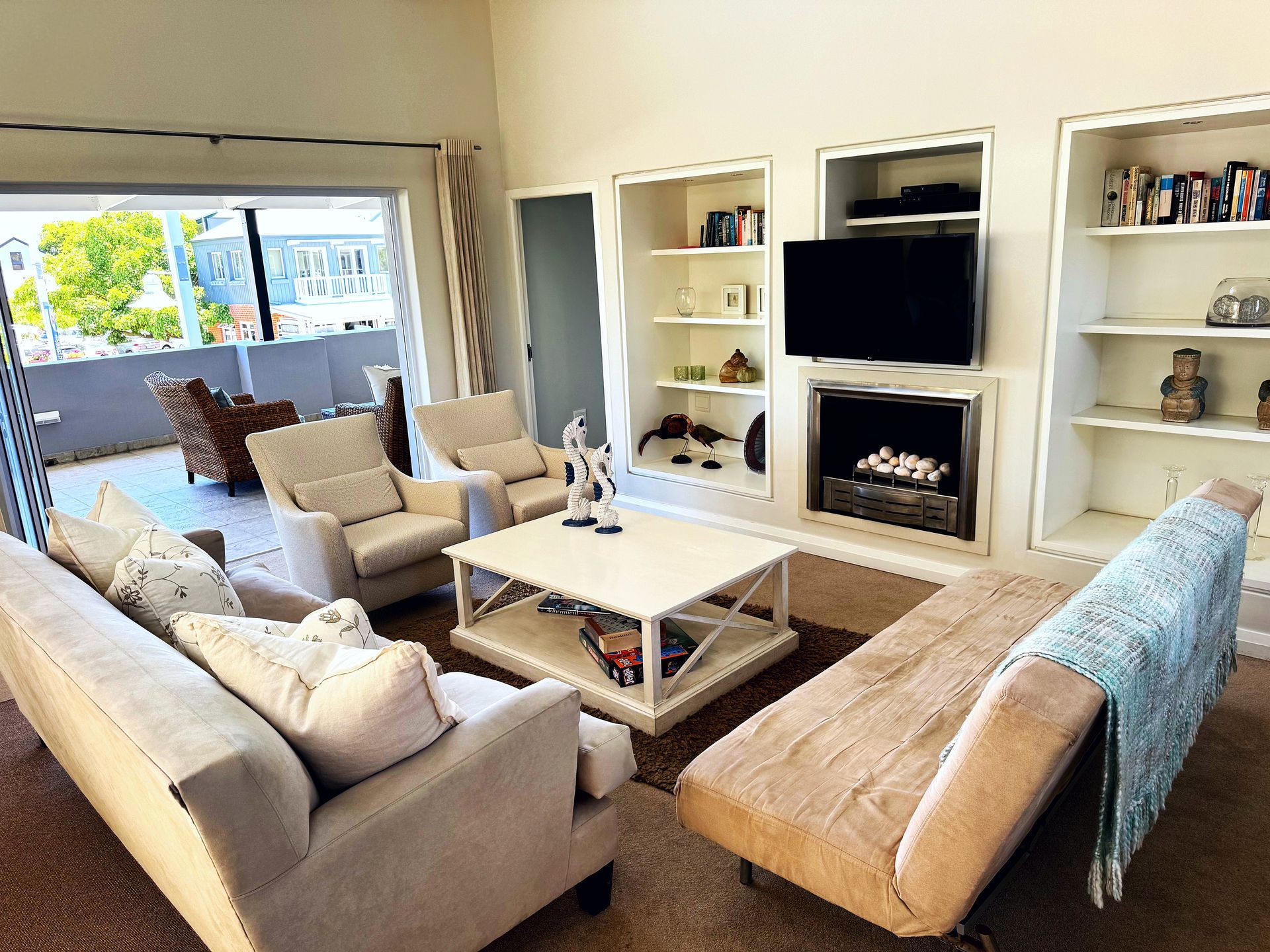 A living room with a couch , chairs , coffee table and television.