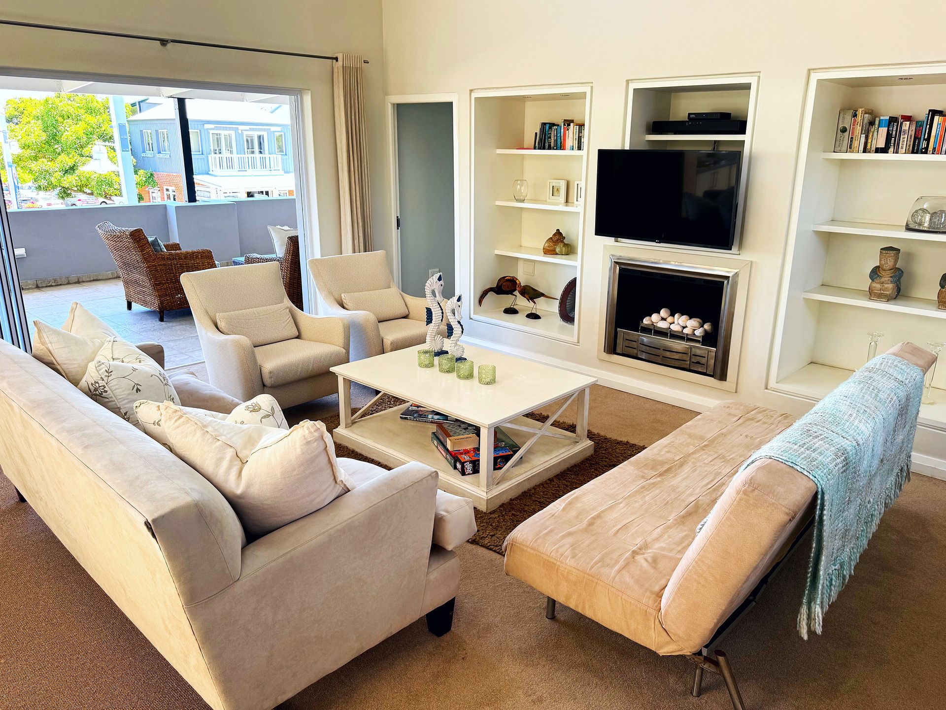 A living room with a couch , chairs , coffee table and television.