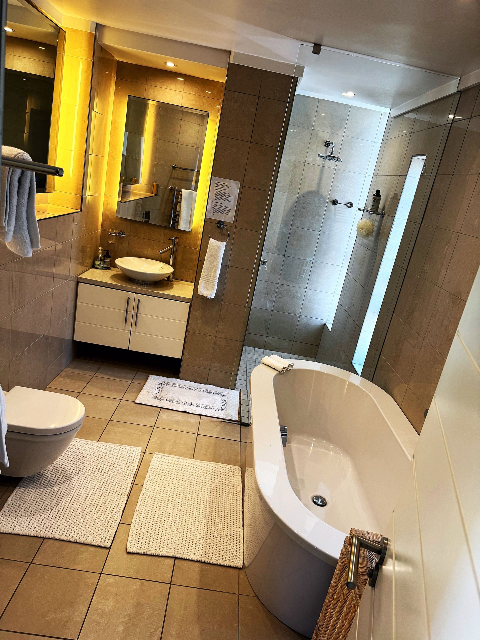 A bathroom with a tub , toilet , sink and shower.