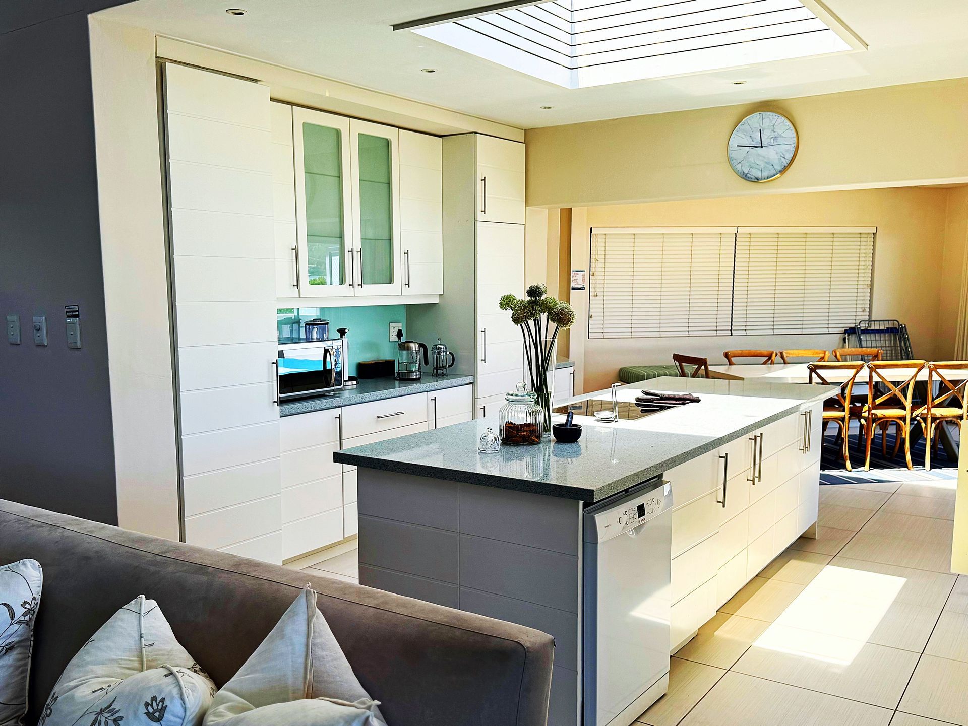 A kitchen with white cabinets and a clock on the wall