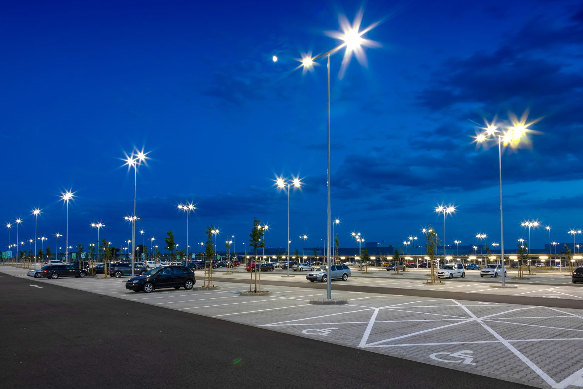 Spacious, well-lit modern parking lot at night .