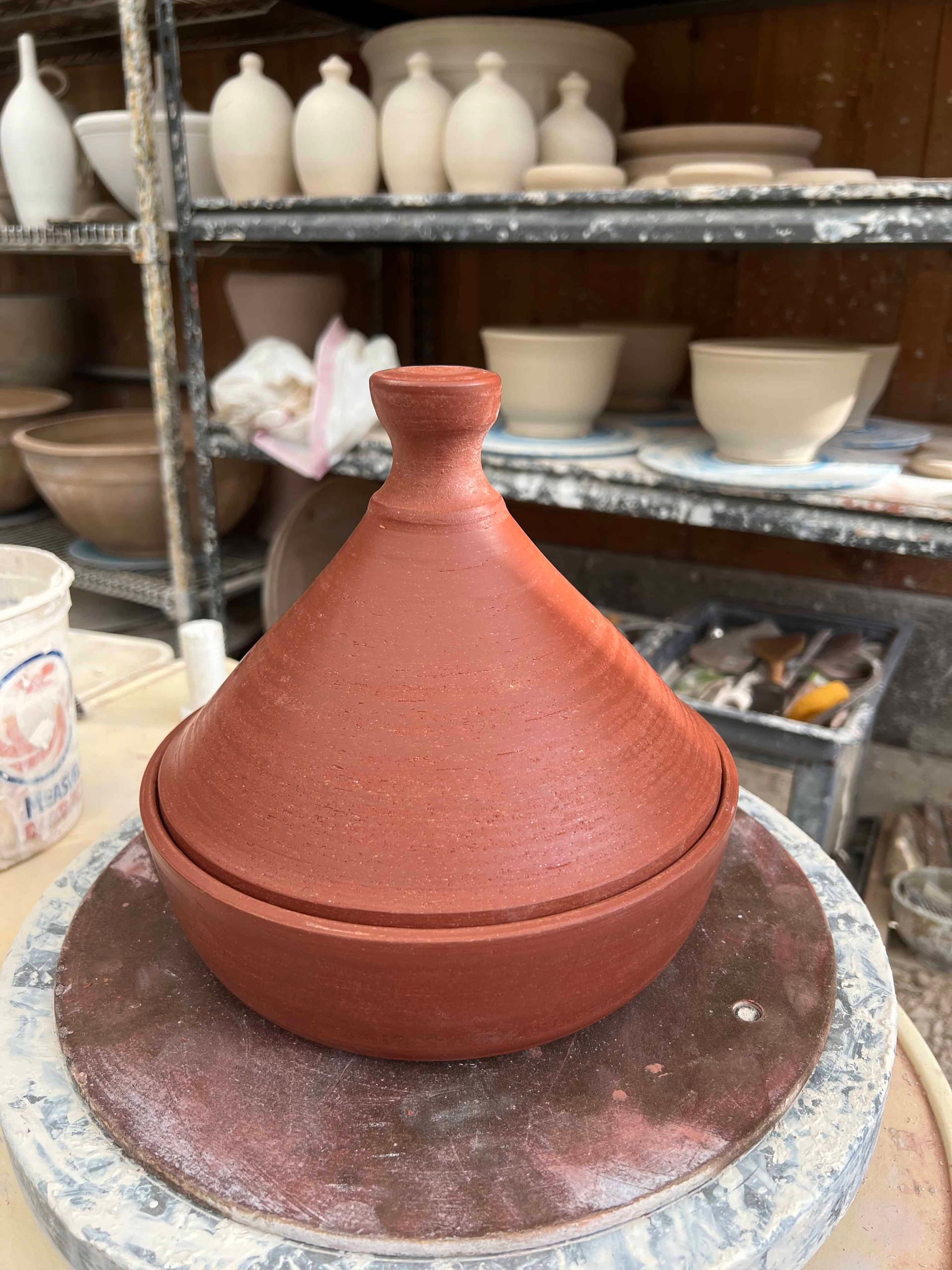 Unpainted terracotta pot with a tall lid