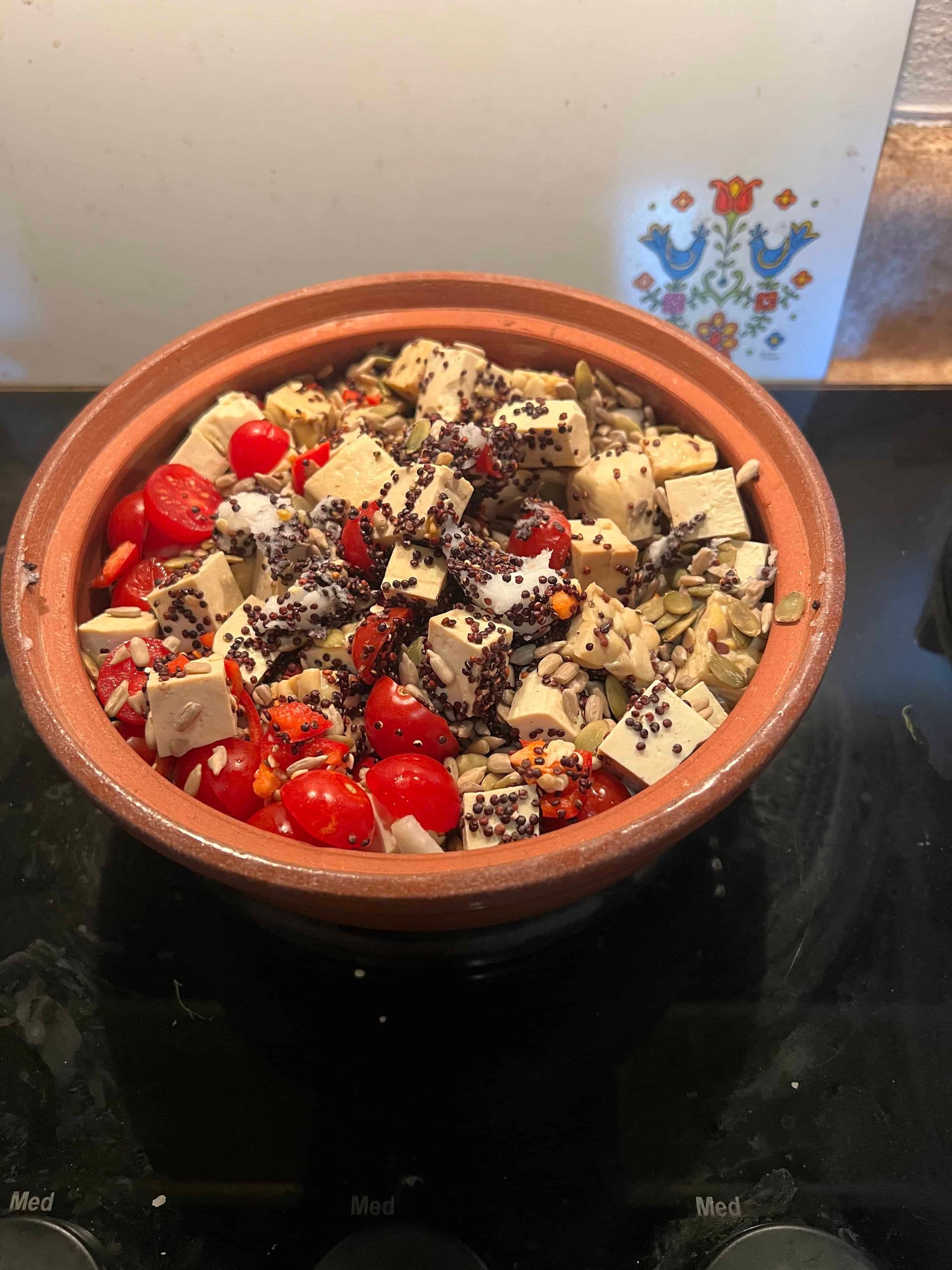Terracotta cookware filled with various vegetables and spices