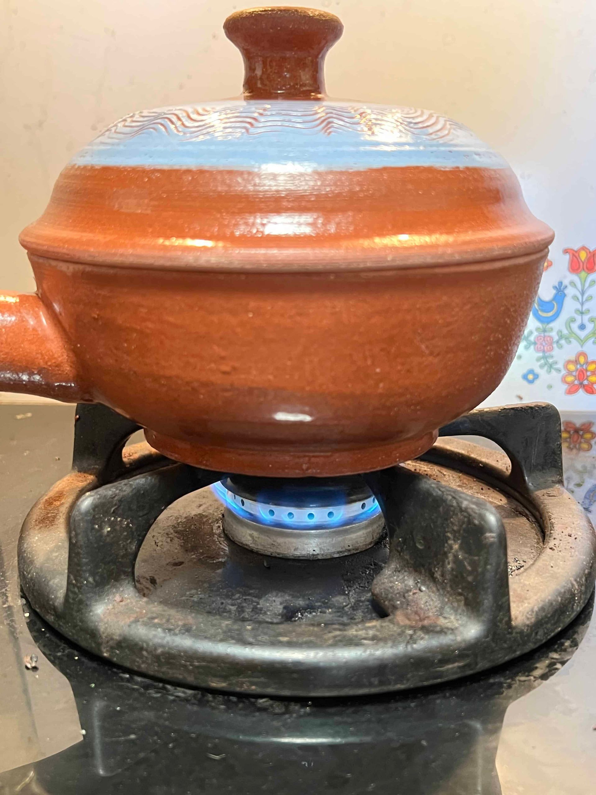 Tuolumne Terracotta cookware on a lit gas stove burner
