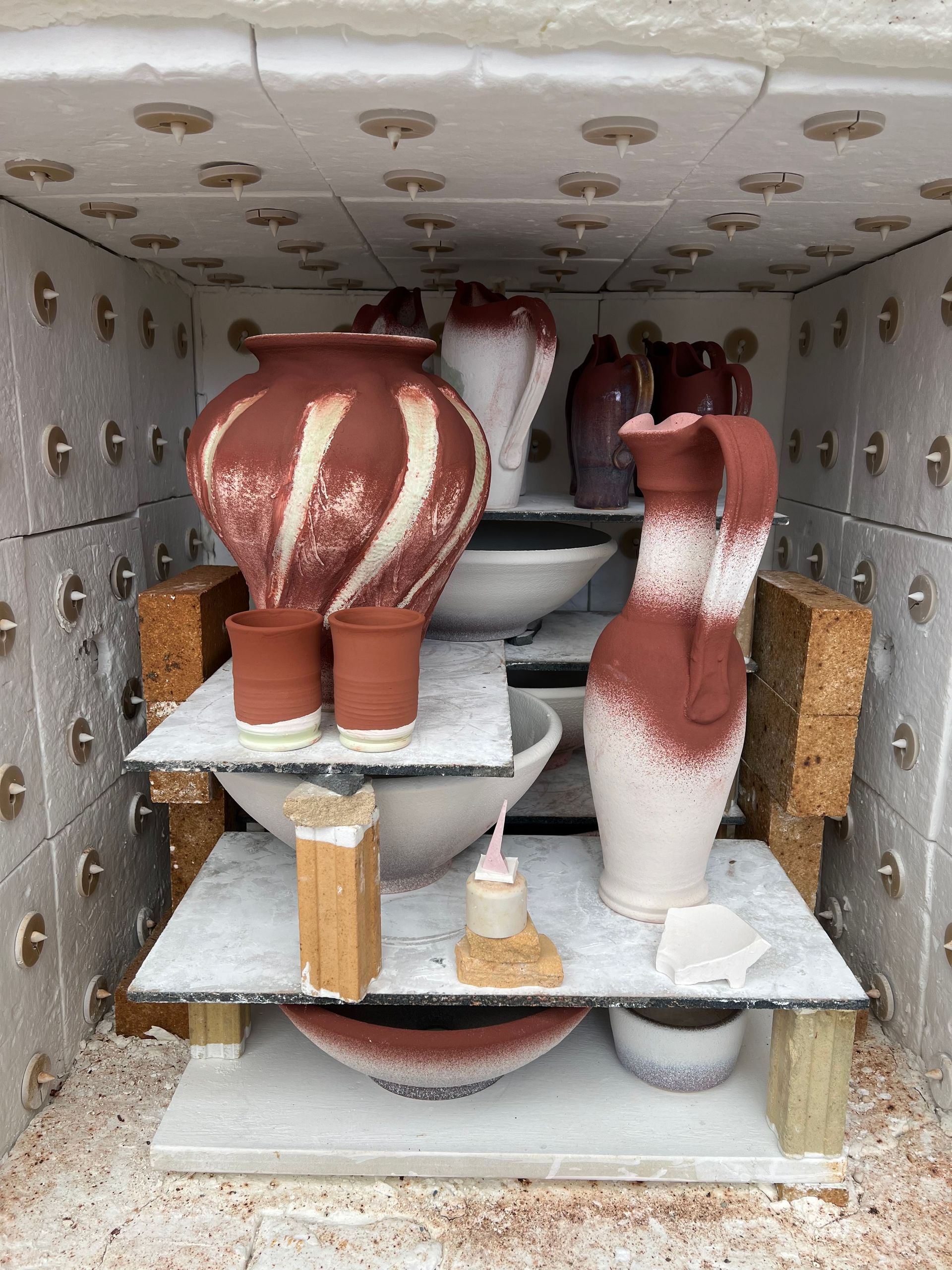 Glazed pots in the production kiln ready to high fired