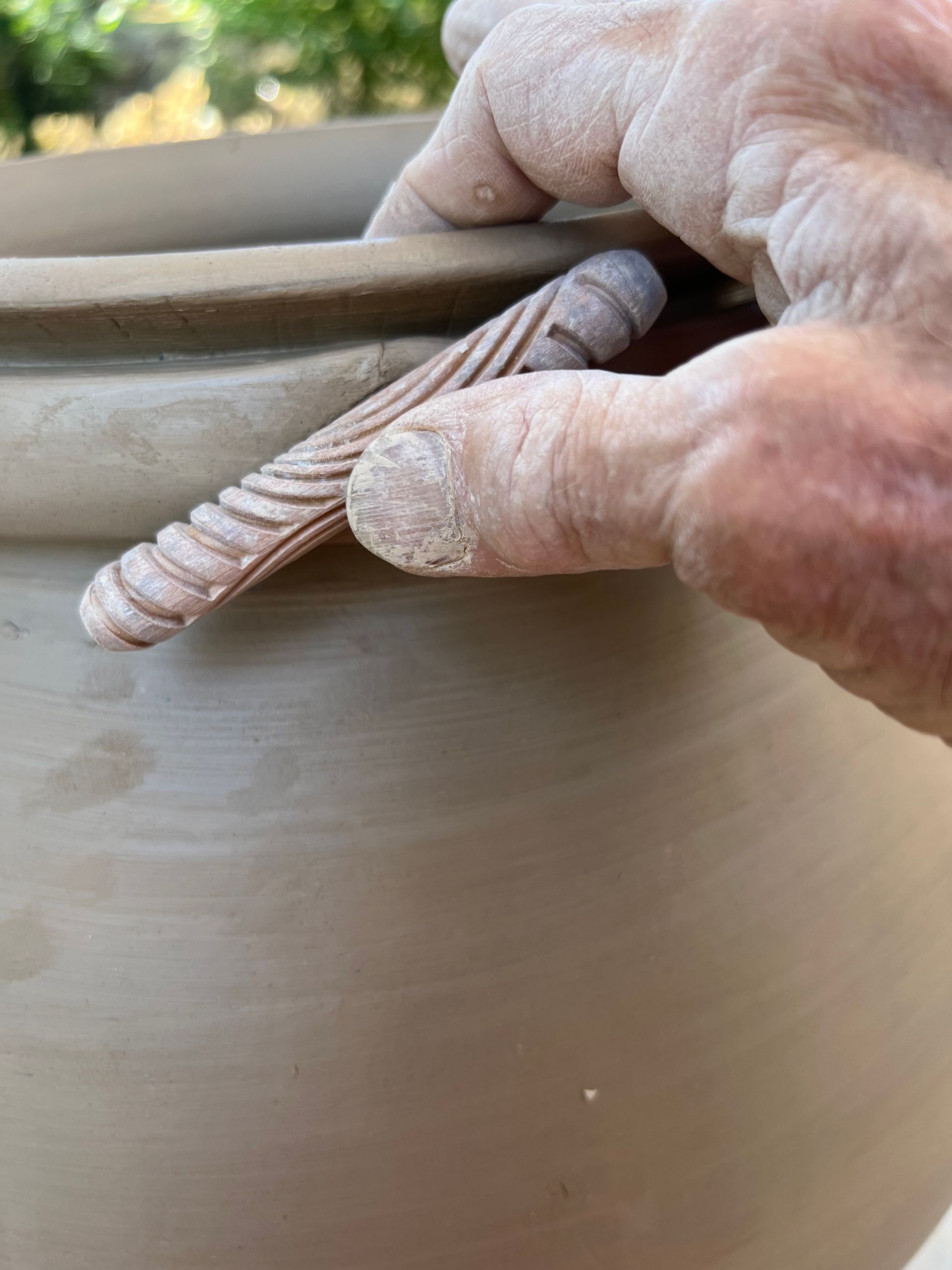 Impressing the pattern and squeezing into the rip of the pot 