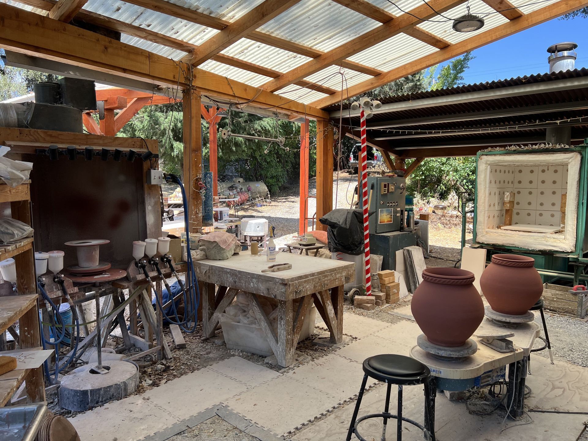 Looking at one of the throwing areas, wedging table, spray booth and production kiln