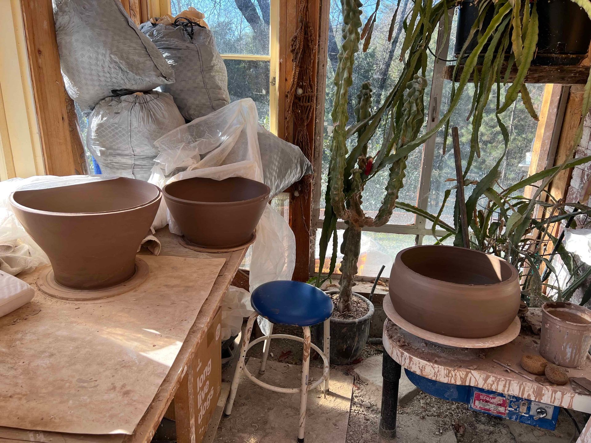 Inside Sunrise Pottery Studio, Three large clay containers sit on counters waiting to be finished