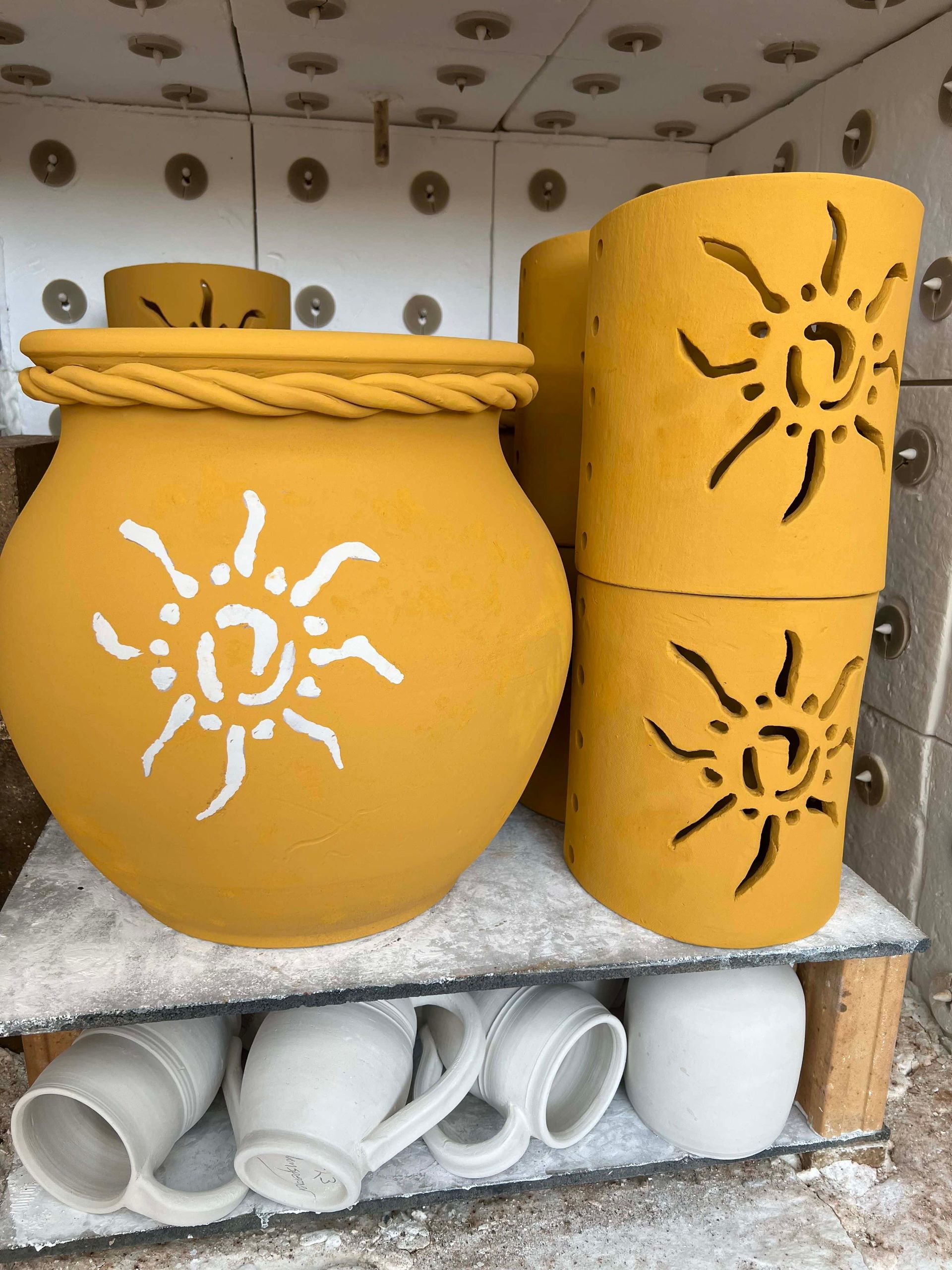 Rain catchers and light sconces in production kiln ready to be fired