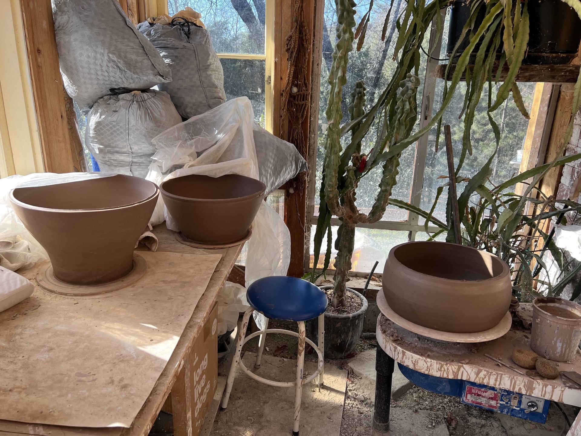 Inside Sunrise Pottery Studio, Three large clay containers sit on counters waiting to be finished