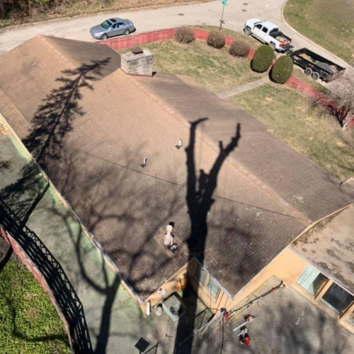 An aerial view of a house with a shadow of a tree on the roof