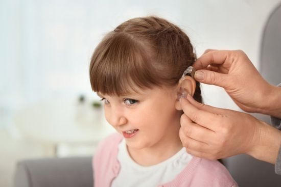 applicazione di apparecchio per l'udito in una bambina