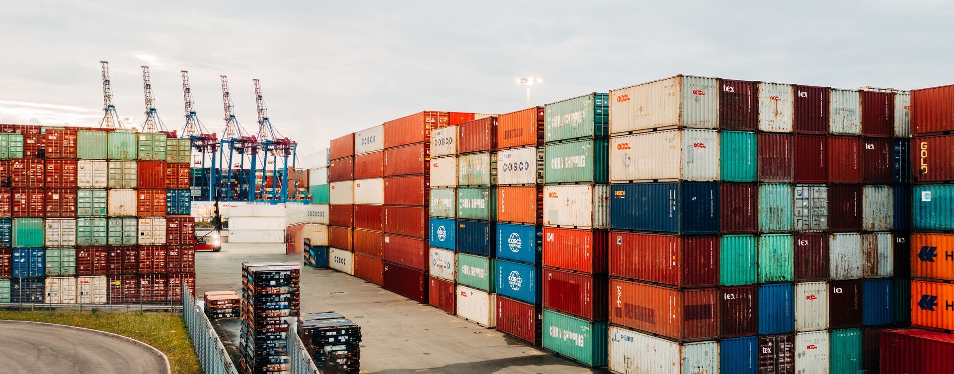 An aerial view of shipping containers stacked up in a port.