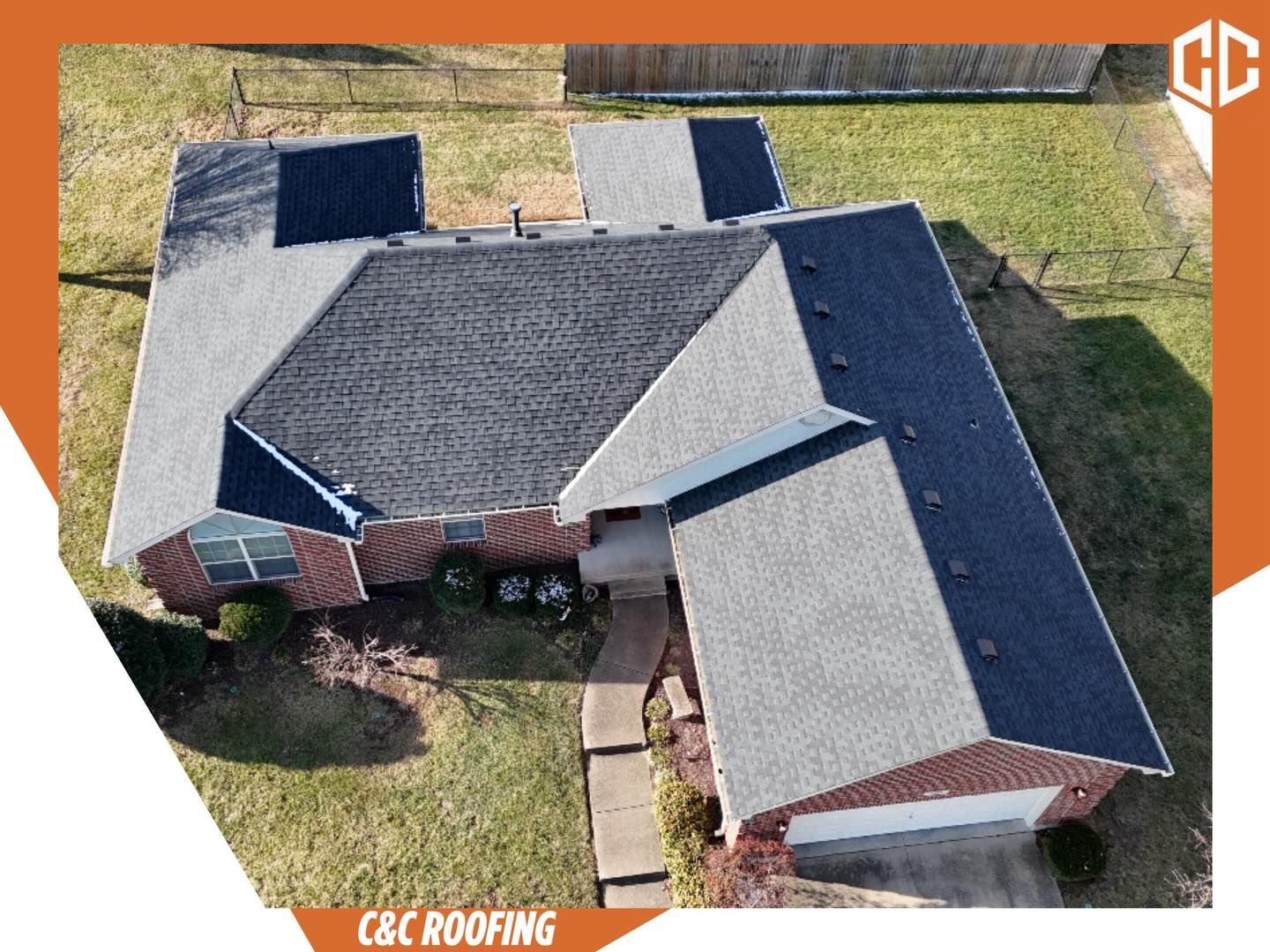 An aerial view of a brick house roof with multi-colored shingles, featuring a C&C Roofing logo in the top right corner.