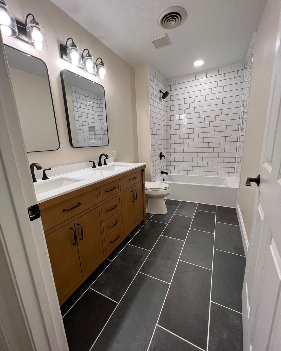 A bathroom with a sink , toilet , bathtub and mirror.