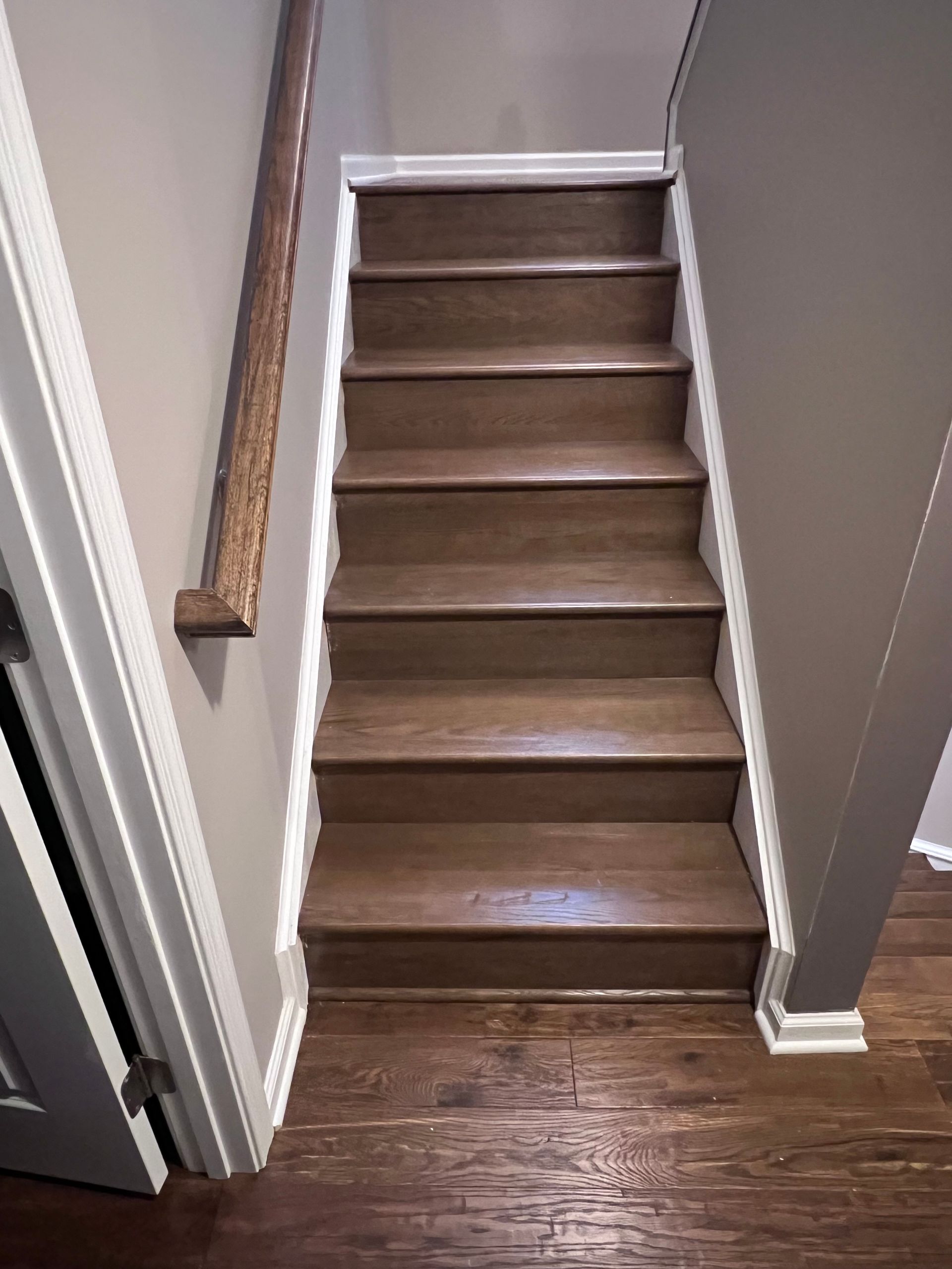 A set of wooden stairs leading up to the second floor of a house.