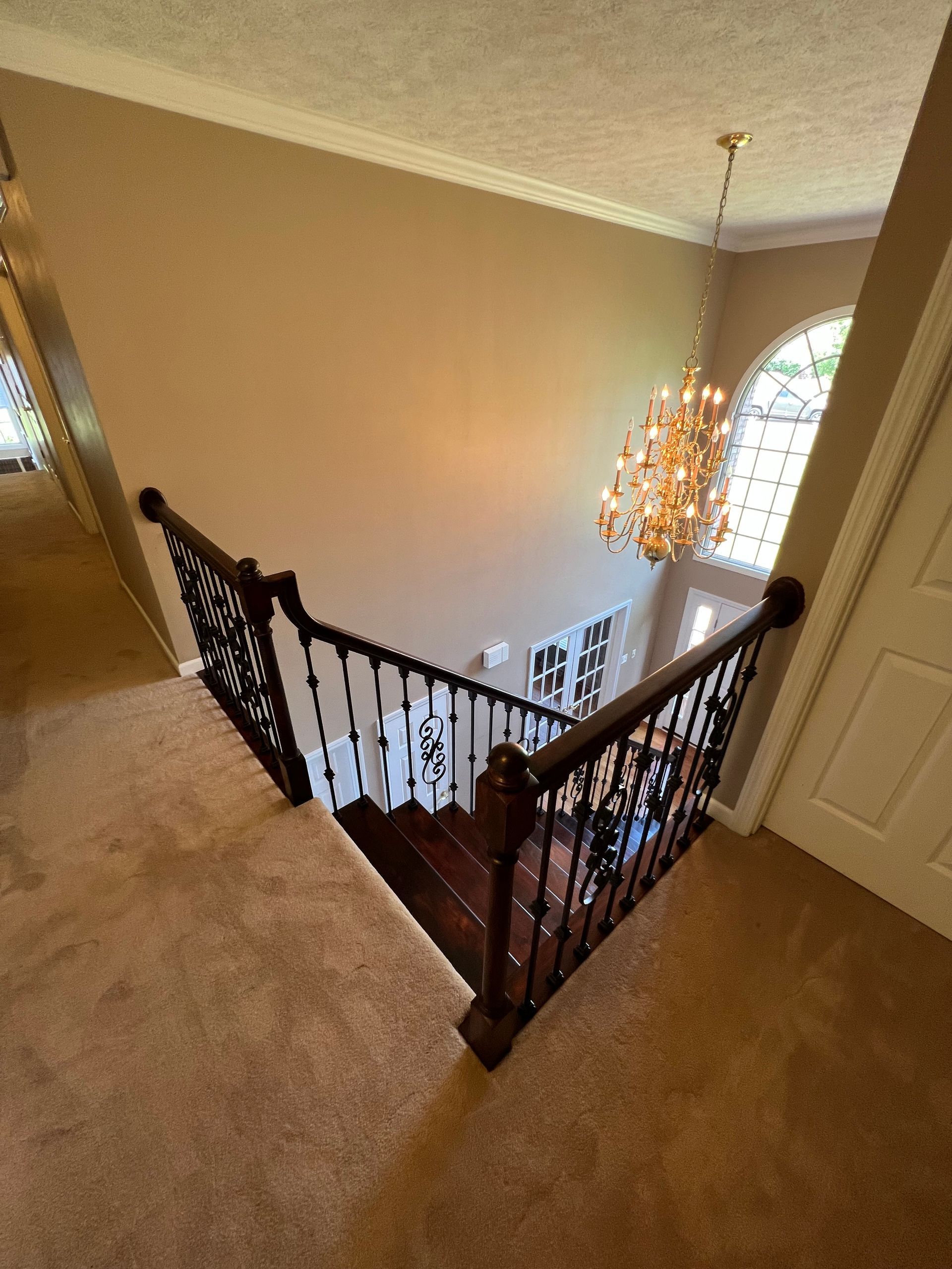 A staircase in a house with a chandelier hanging from the ceiling