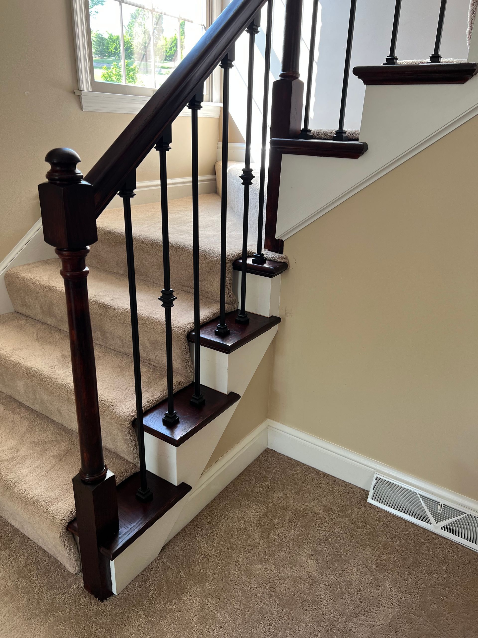 A staircase with carpeted steps and a wooden railing